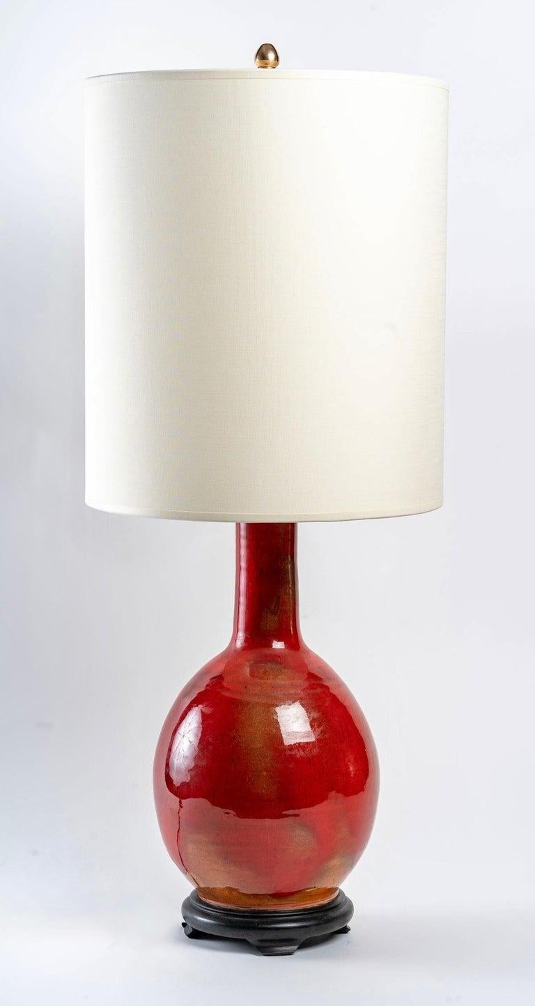 Belle lampe en faïence de forme balustre, émaillée d'un camaïeu de rouge appelé 