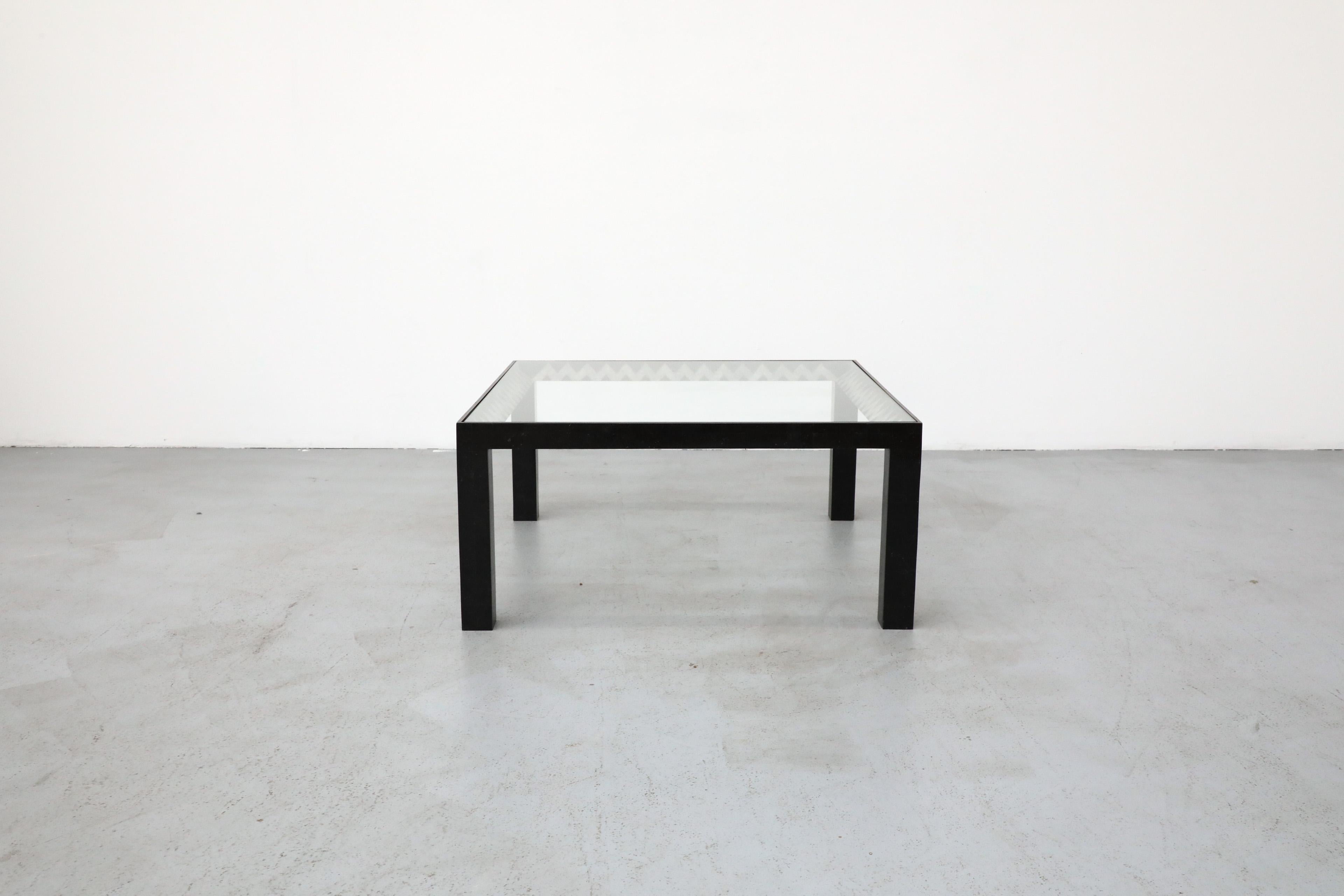 Tavolino in marmo tessellato di Maitland Smith con piano in vetro, circa 1970. Questo tavolo, firmato Maitland Smith, presenta un intarsio a zig-zag in pietra grigia rifinito in ottone, visibile attraverso il vetro del piano, e una cornice quadrata