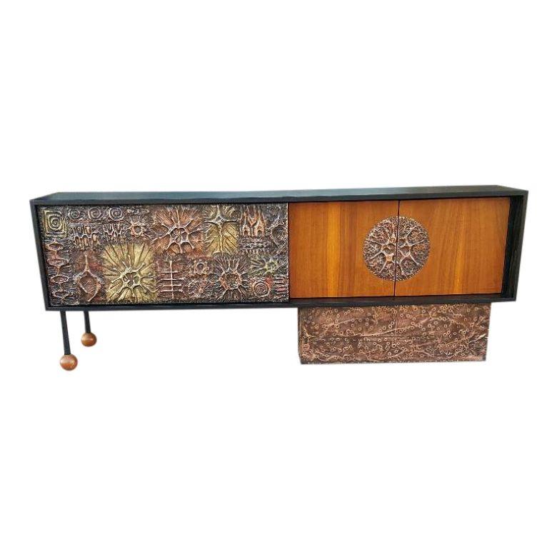 Vintage Credenza with Brutalist hand sculpted copper tiles by Artist Lou Ramirez. Natural walnut doors with circular hand sculpted copper decorative tile design on the right sided doors, opening to large storage area. Brutalist copper & brass hand