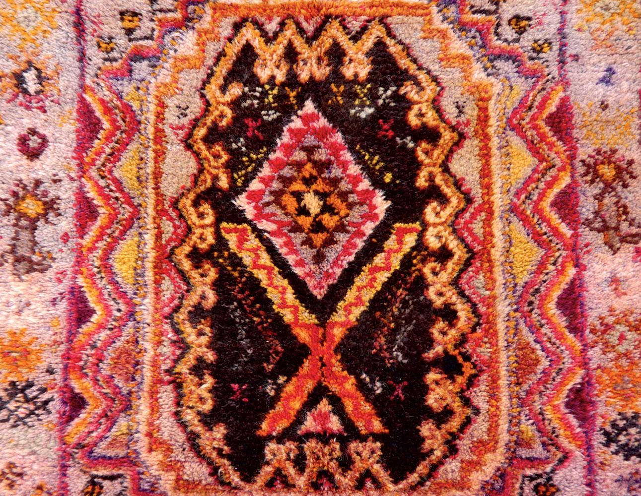 Alfombra marroquí Taznakht tejida a mano con sedosa lana roja, dorada, gris y negra en complejo dibujo bereber adornado con teteras ceremoniales a ambos lados del borde.
Dimensiones: 4'4 x 9'