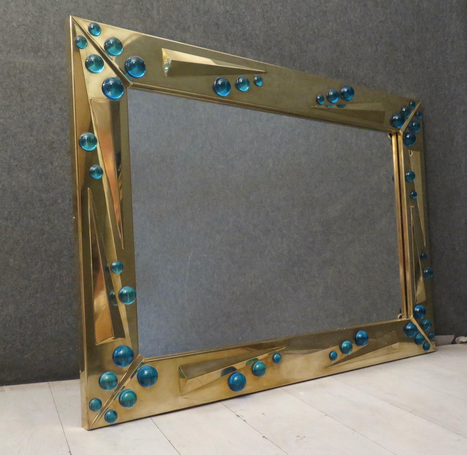 Very special Murano glass mirror from the middle of the century, exalting for its color and design.

All brass frame, with brass and glass inserts. On the frame all in brass there are some big lenses in Murano glass, in blue color. The mirror can be