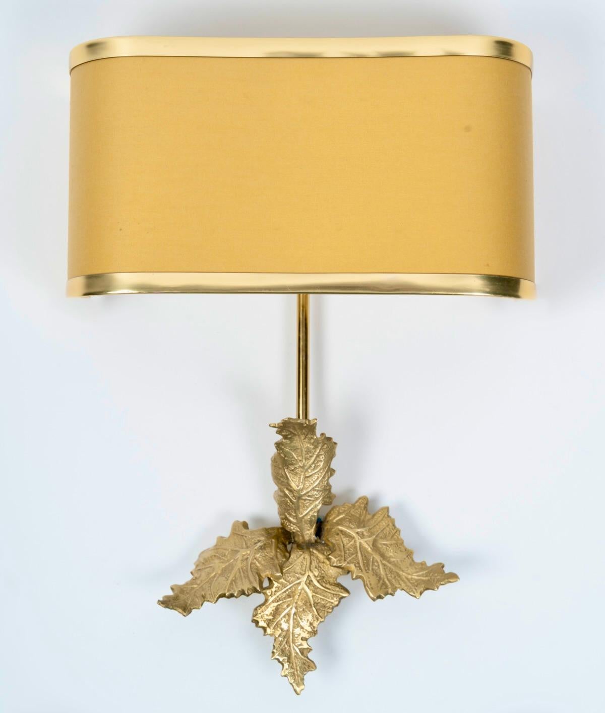 Pareja de apliques de bronce dorado y latón de Maison Charles.

Compuesta por una varilla central redonda de latón dorado decorada en la parte inferior con hojas de bronce dorado, rematada en la parte superior por una pantalla de banda realzada por