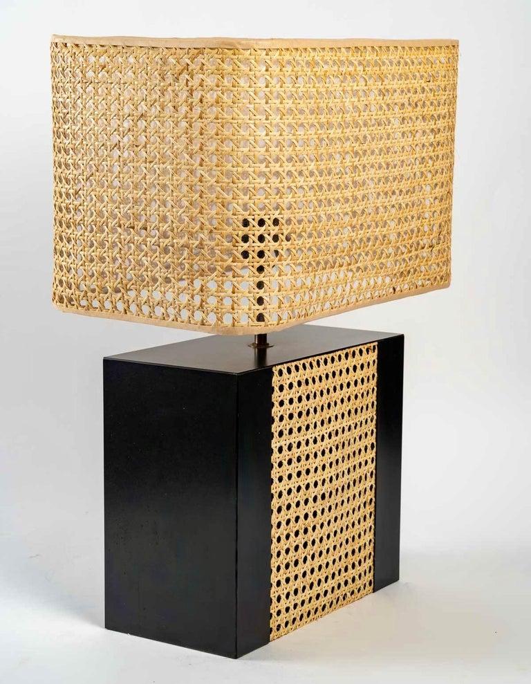 Composed of a rectangular base in black laminate decorated on the main face with a wide strip of honey-colored cane.
They are dressed with a lampshade of rectangular form in Parisian cane matched with the cane of the base.
2 bulbs per lamp.