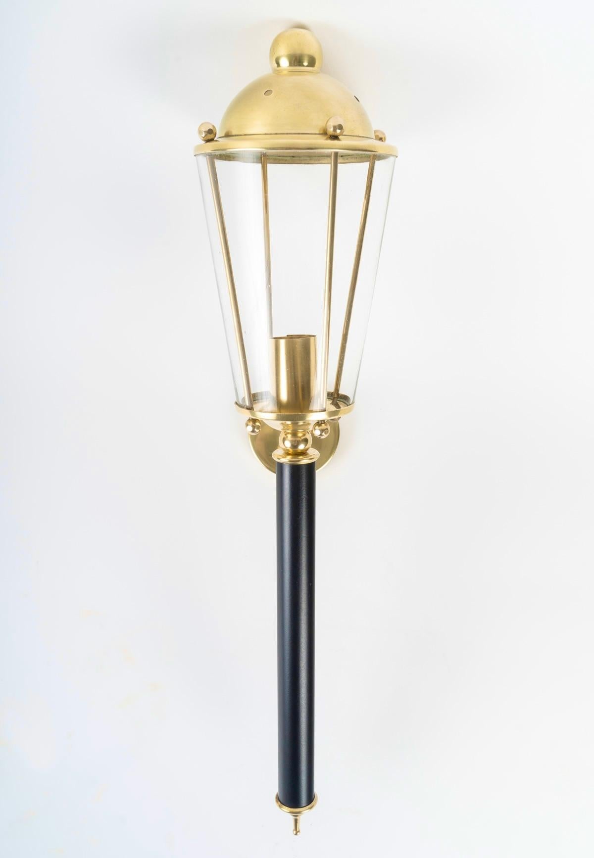 Composed of a blackened wood arm highlighted by a gilded brass spinning top at the bottom.
On the upper part, the lantern rests on a gilded brass base on which rests a glass protected by 4 gilded brass rods and highlighted by a gilded brass