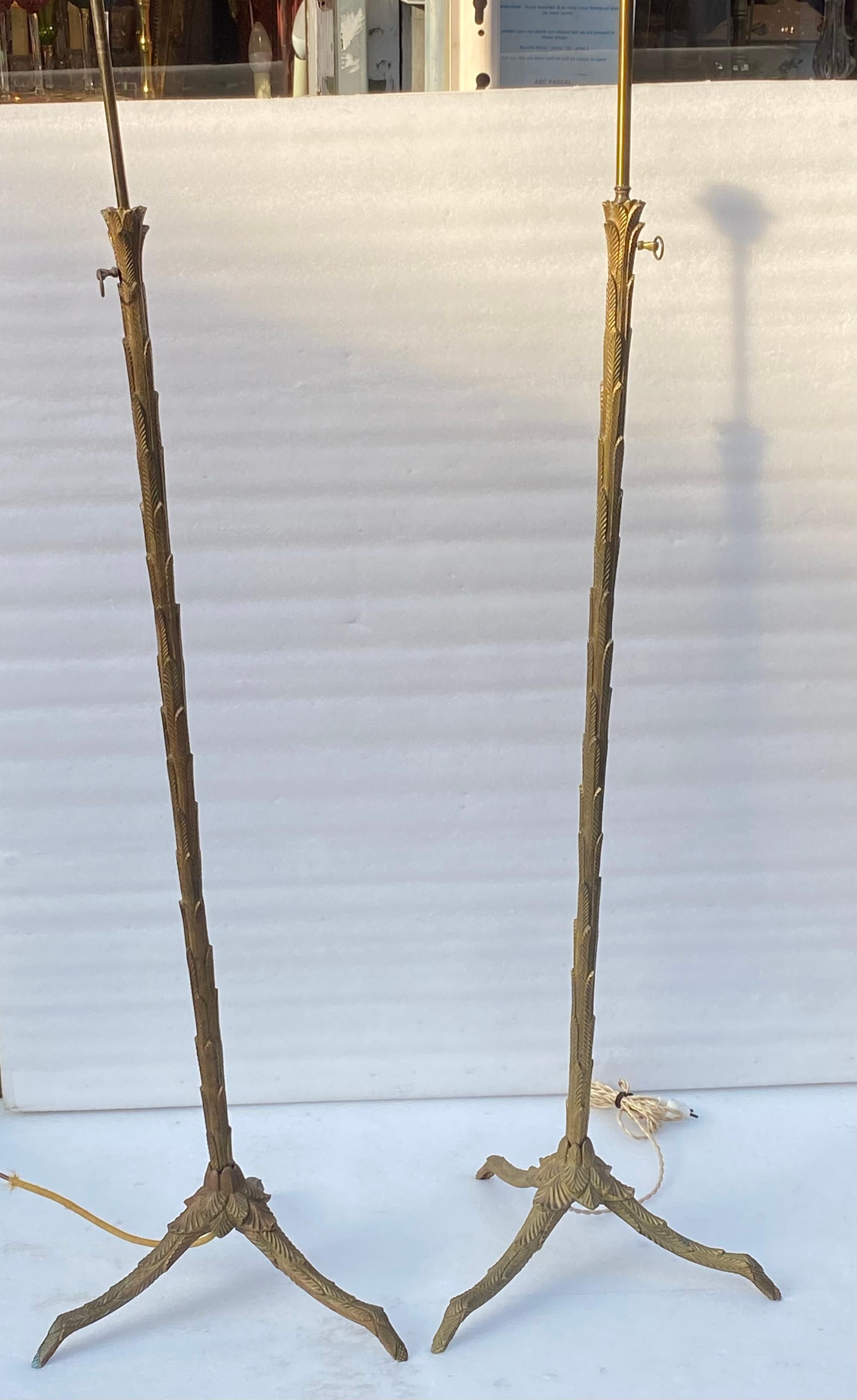 Pareja de lámparas de pie de bronce regulables en altura,
 estado de uso vintage,
Circa 1950/70, elementos atornillados, el fuste decorado con una palmera descansa sobre una base trípode decorada con hojas,
Altura: 123 cm
Extensión de 30 cm Tuerca