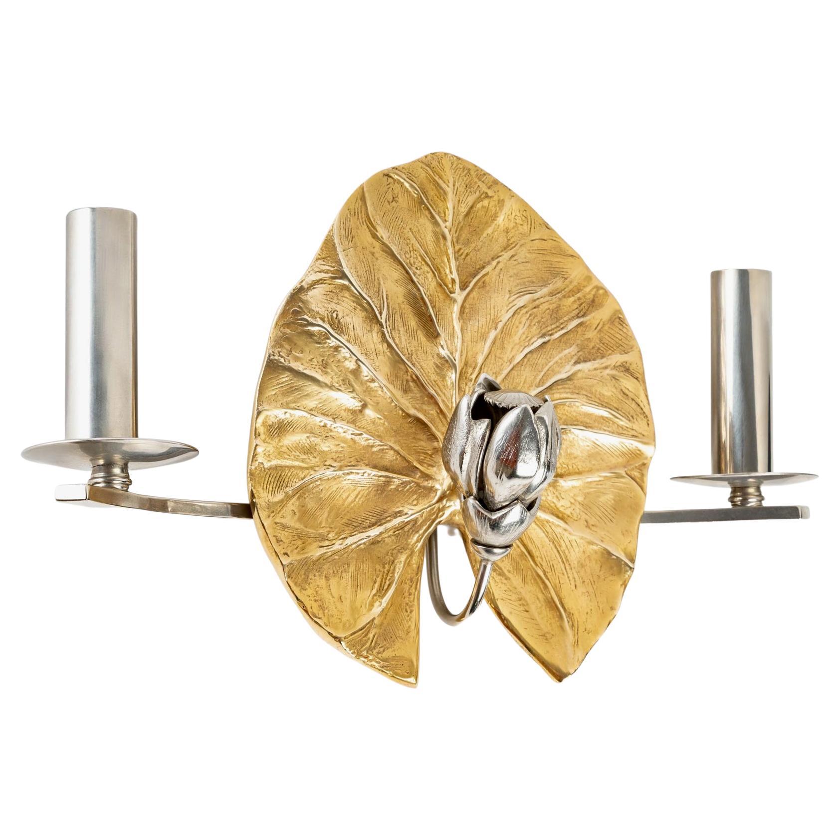 Referenced on the catalog.
Composed of a water lily leaf in gilded bronze signed C Charles on the back serving as a wall support (see photos). On the front, a water lily flower in silvered bronze enriches the decoration.
Two arms in silvered