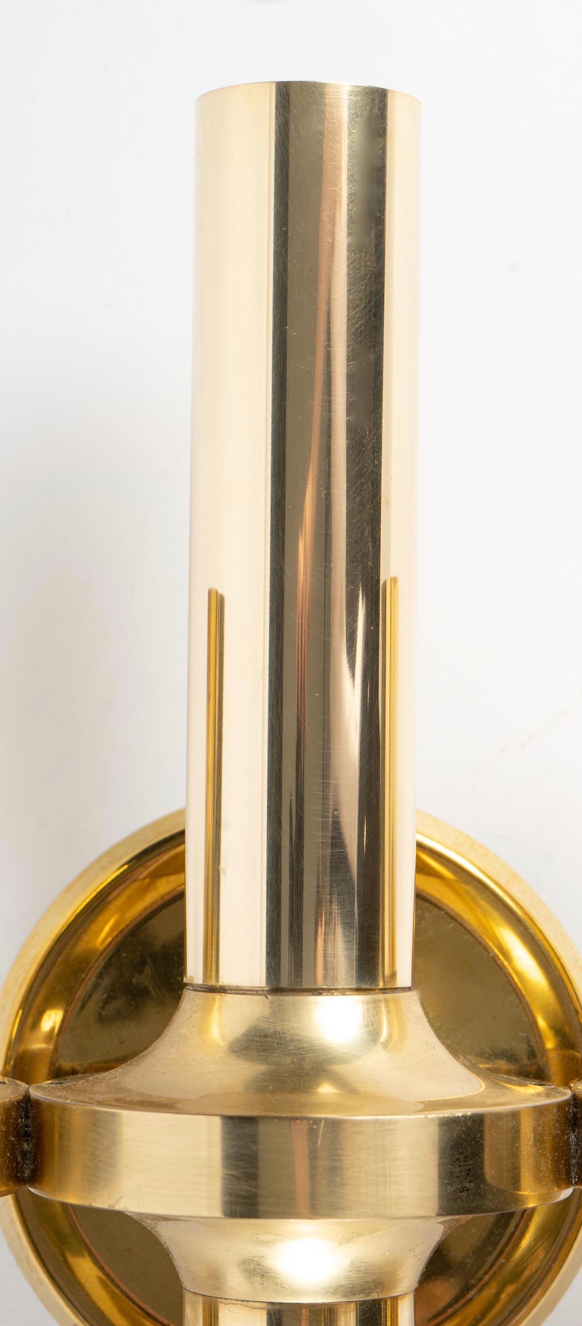 Composed of a round back plate on which is positioned three cylindrical tubes decorated with spinning tops placed in the center of each tube.
The central tube is larger than the two other tubes placed on each side of the sconce.
The 3 tubes receive