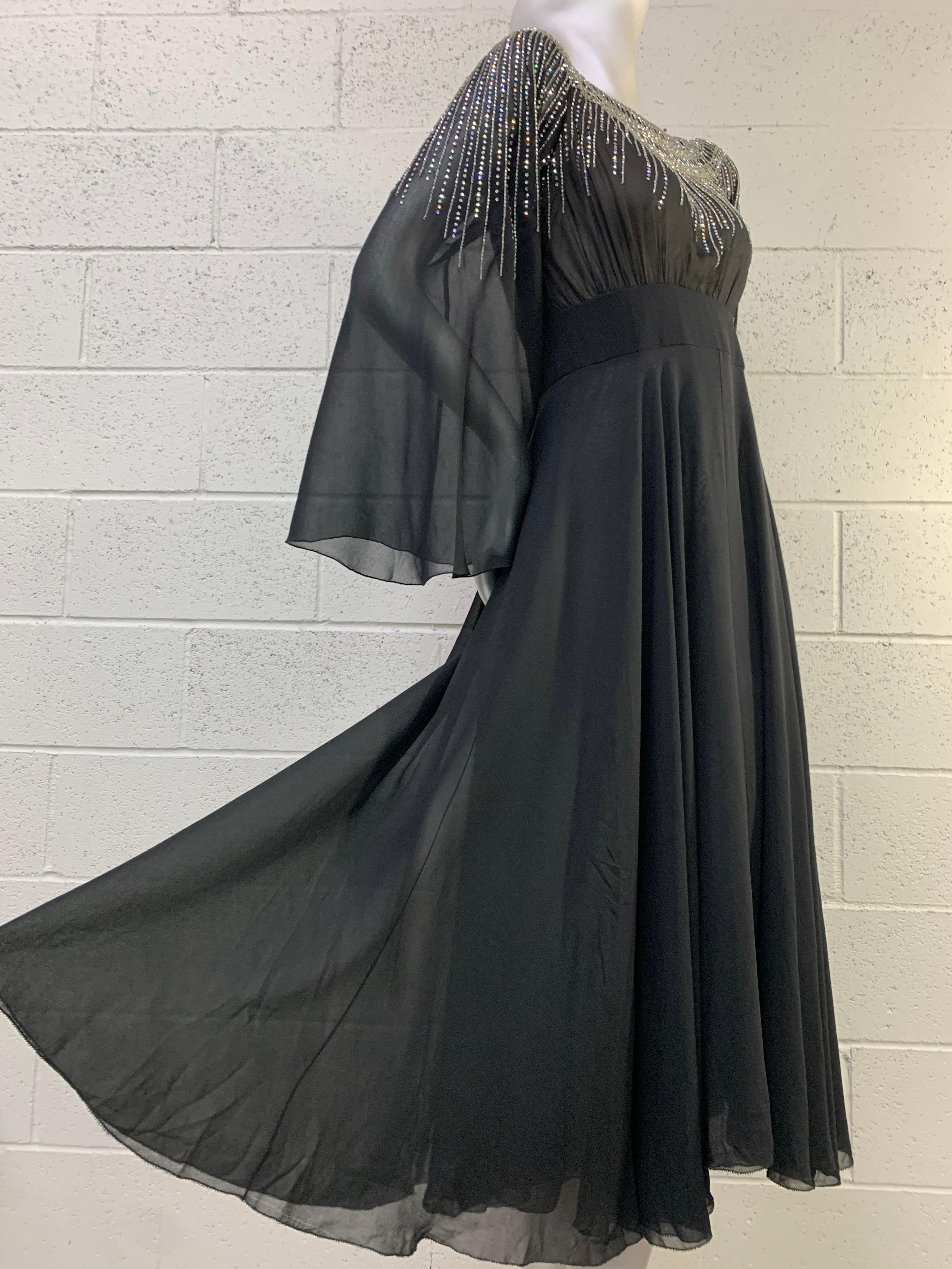 A lovely early 1970s Pauline Trigere black silk chiffon dancing dress--flowing and graceful in a 1930s-inspired design with dramatic beaded and rhinestone starburst design at neckline. Bell sleeves. Double layered chiffon and lined body. Banded