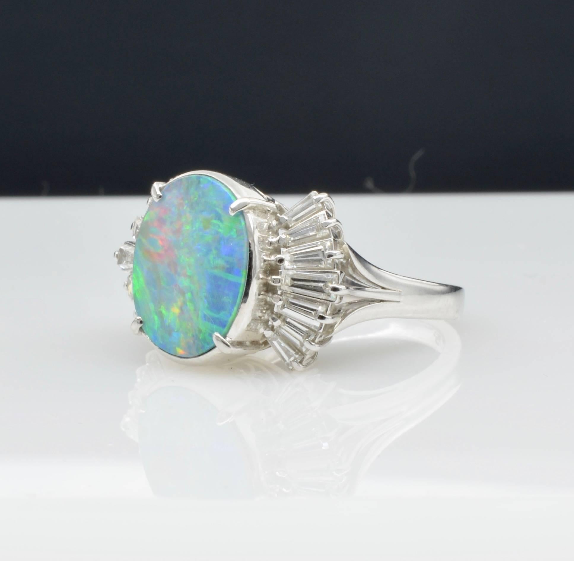 This stunner is a radiant doublet opal aprox. 4.68 ct. surrounded by 0.78 ct diamond baguettes set in platinum. An amazing example of 1970's design and influence. The ring size is 6 1/4 and can be sized to fit your finger.