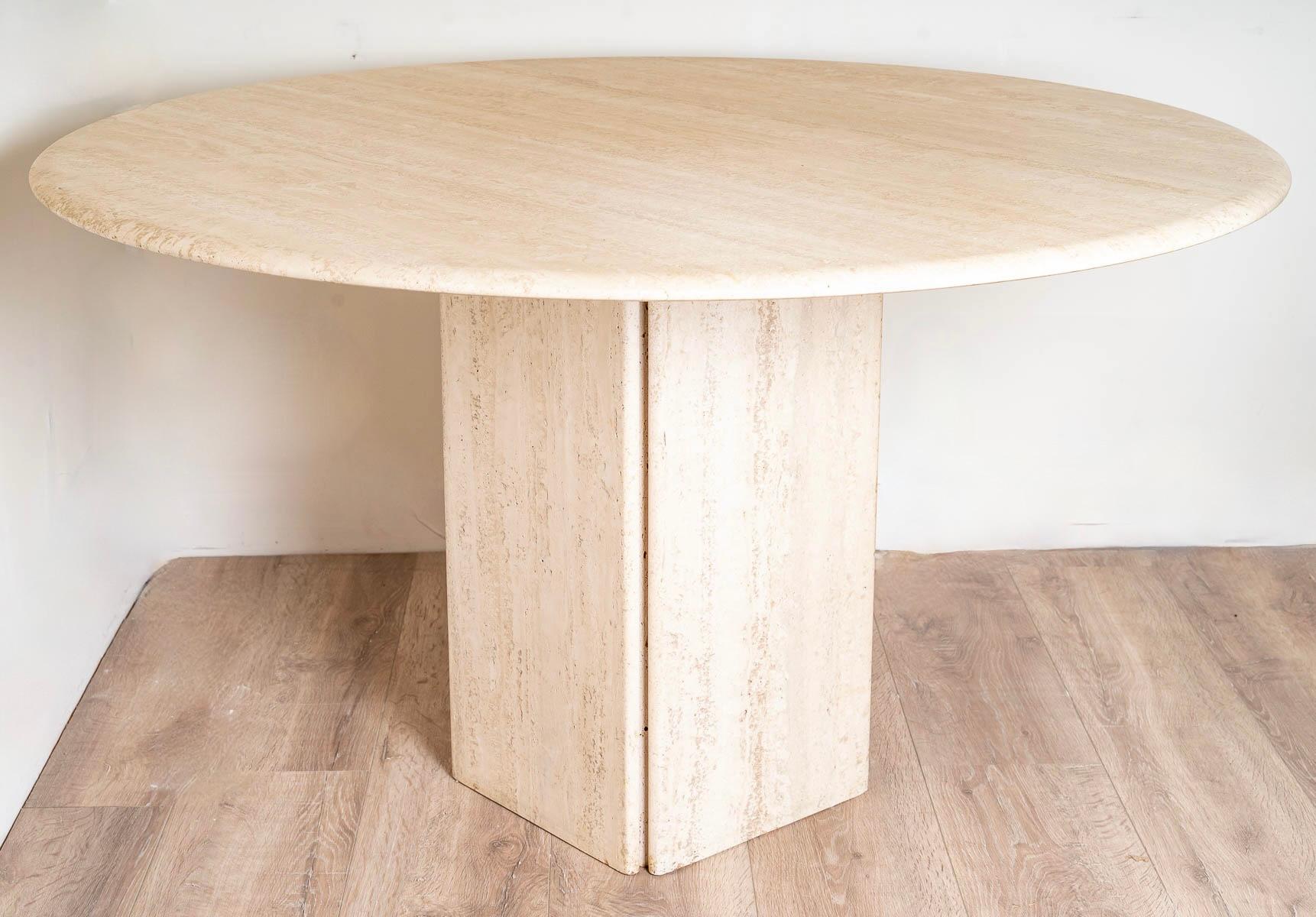 Table composed of an attractive round travertine top finished in doucine placed on a base composed of 4 travertine rectangles assembled offering the possibility to present it visually flat side or point. 
It can be presented as a small dining room