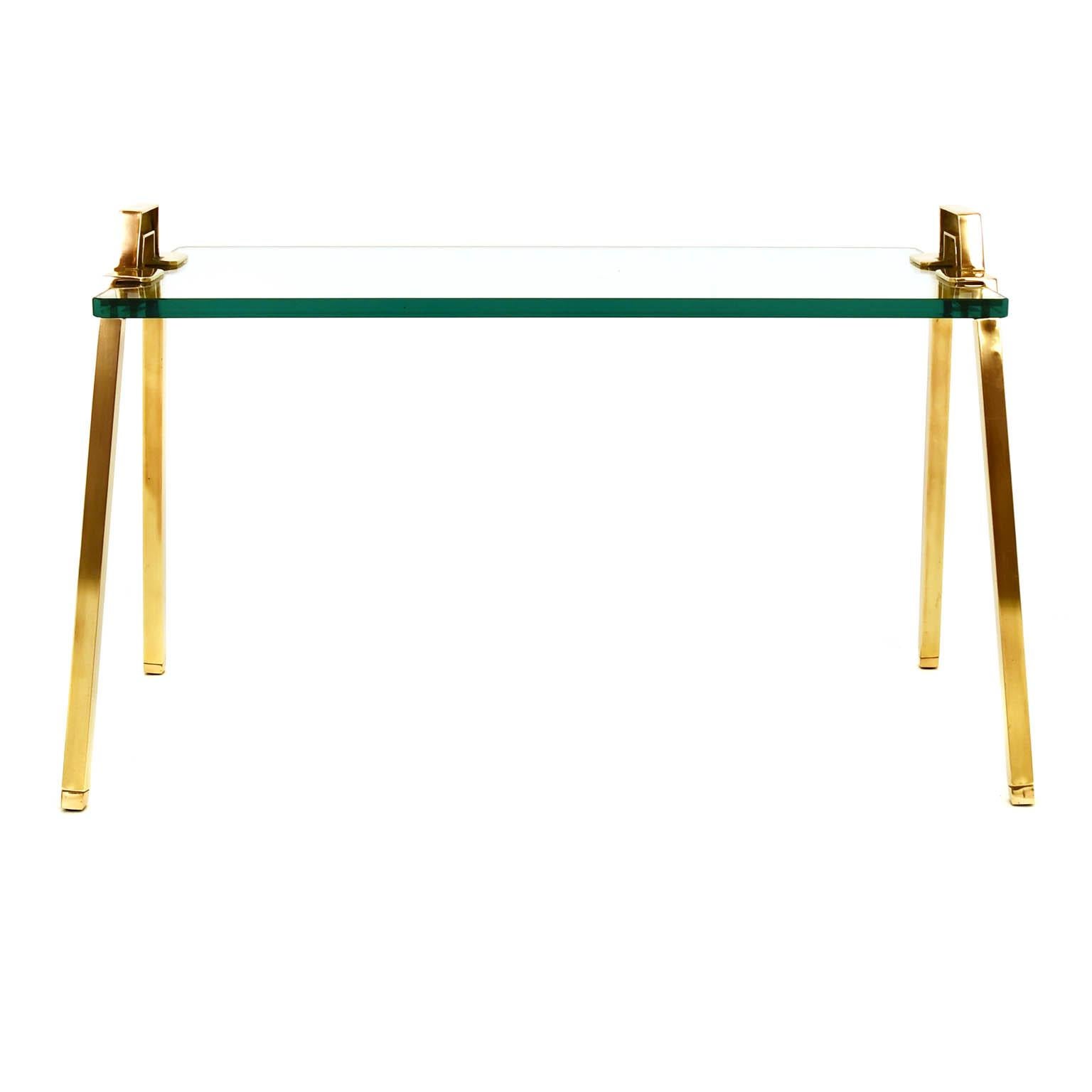 Coffee table by Peter Ghyczy in solid brass and a thick glass top. The legs are designed to be also handles to move the table easily and use it also as a kind of serving tray. The base is made of solid brass tubes and a cast metal