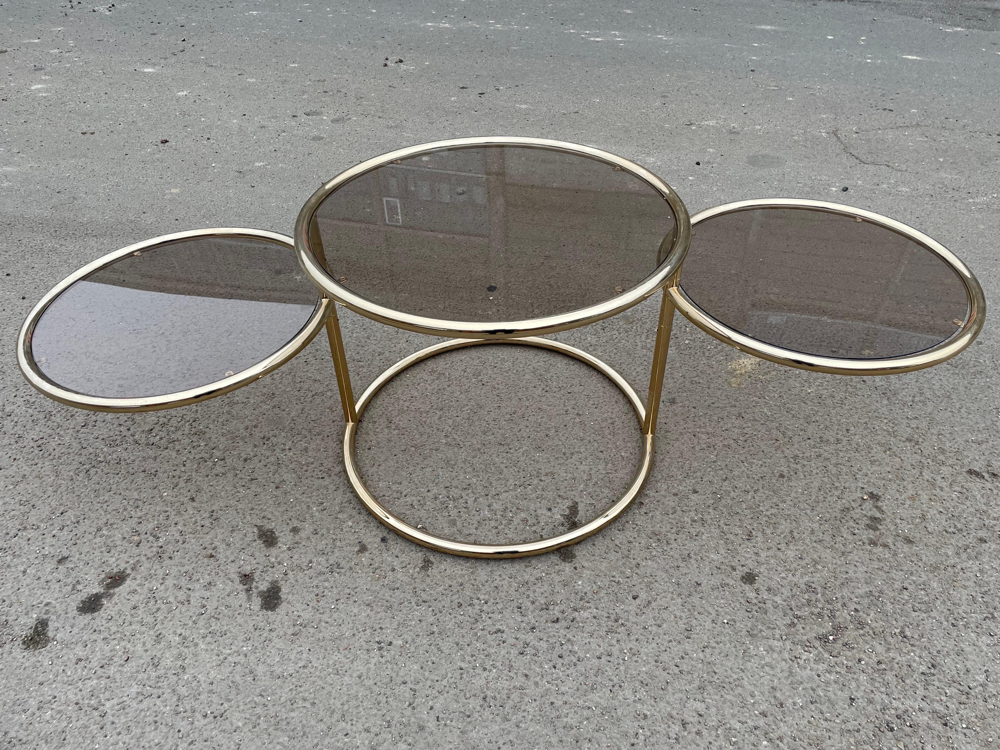 A versatile cocktail table comprised of three tiers of polished brass tubular framed glass tables; The two tables have a diameter of 55 cm. Morex, Italian, circa 1970