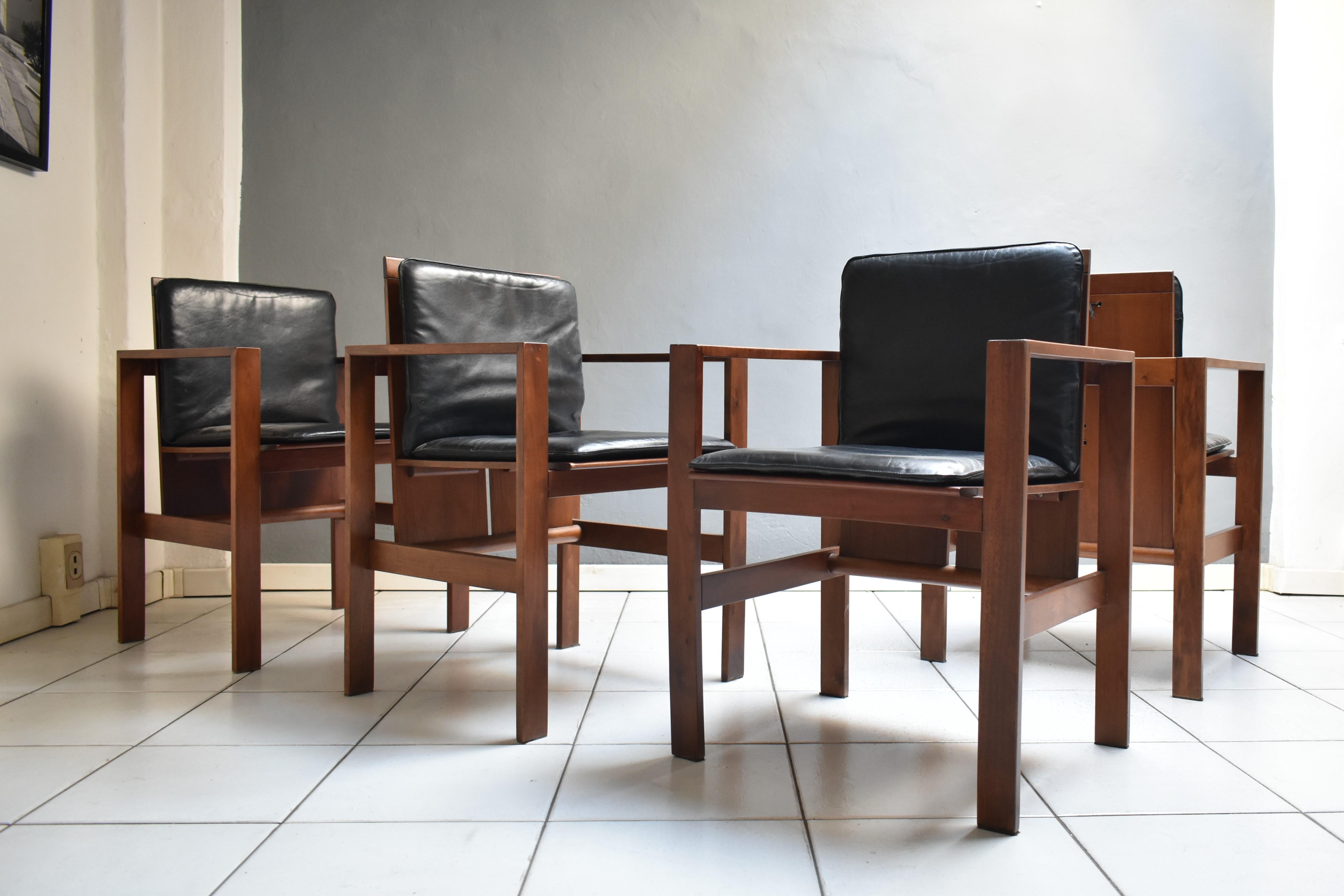 Set of 4, vintage 1970s chairs, designed by architect Antonio Virgilio for Bernini. The chairs with armrests have a walnut wood structure with seat and back cushions in black leather.
Original upholstery, on the lining there is the manufacturer's