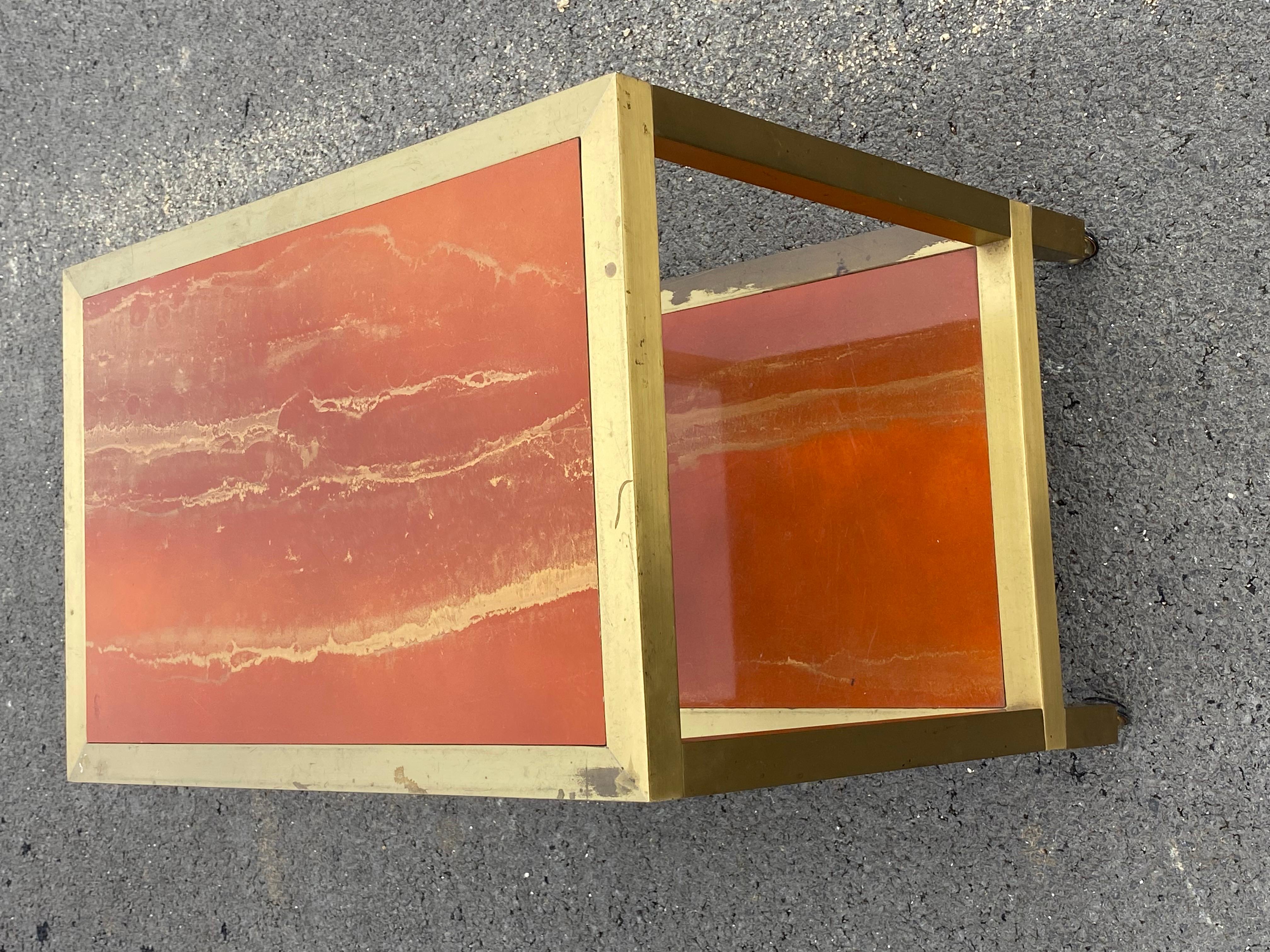 Wagen aus patiniertem Messing mit 2 hölzernen Etagen, die mit orangefarben lackiertem Melamin mit Golddekor bedeckt sind,
Arbeiten von Guy Lefevre oder Willy Rizzo für Maison Jansen
CIRCA 1950/70
Verwendungsbedingung
Länge: 60 cm
Breite: 40 cm
Höhe: