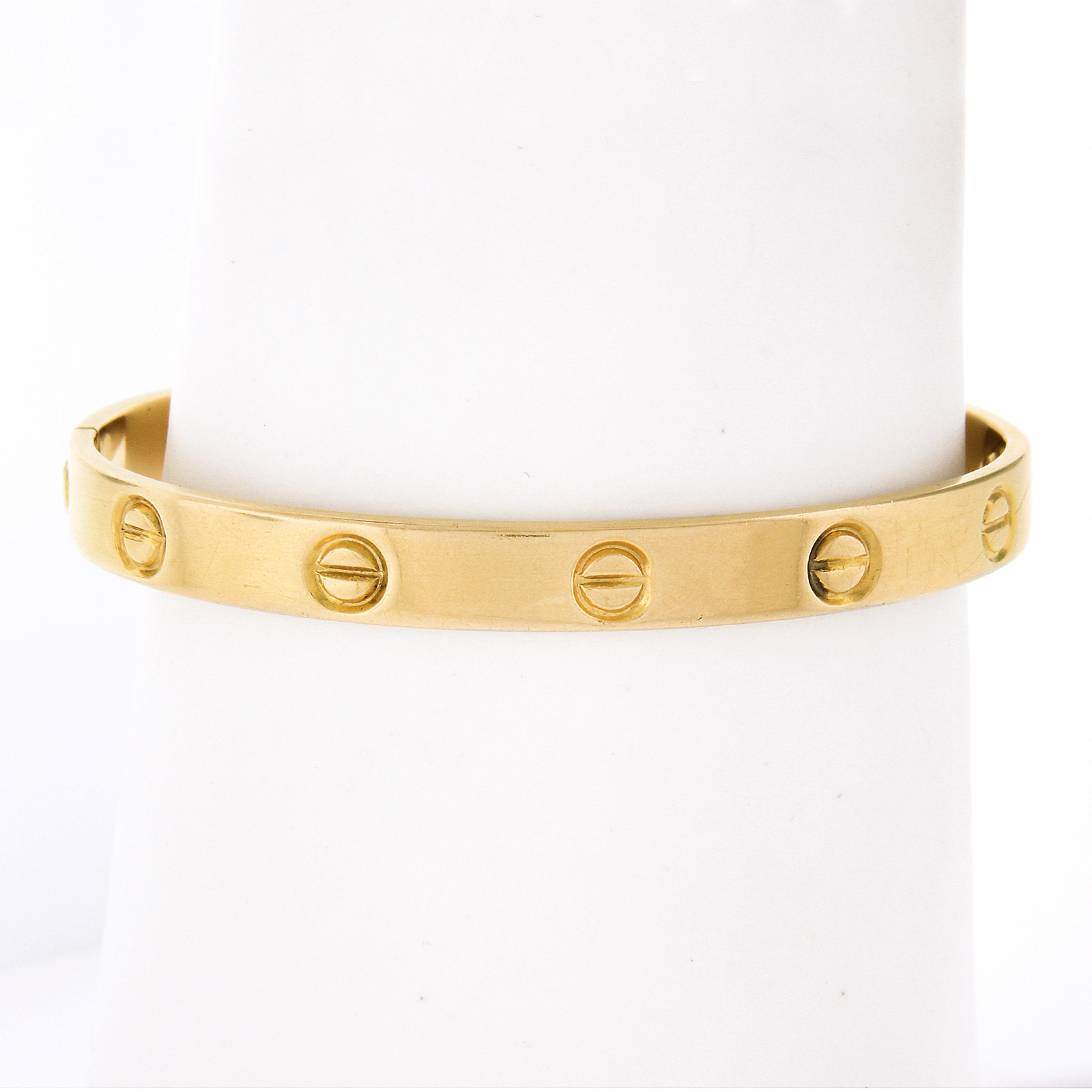 A French-made, early production, vintage 1970 Cartier love bracelet designed by Aldo Cipullo and crafted in solid 18K yellow gold. A simple, iconic design that is still produced by Cartier today. The bracelet has two functioning screws which bolt it