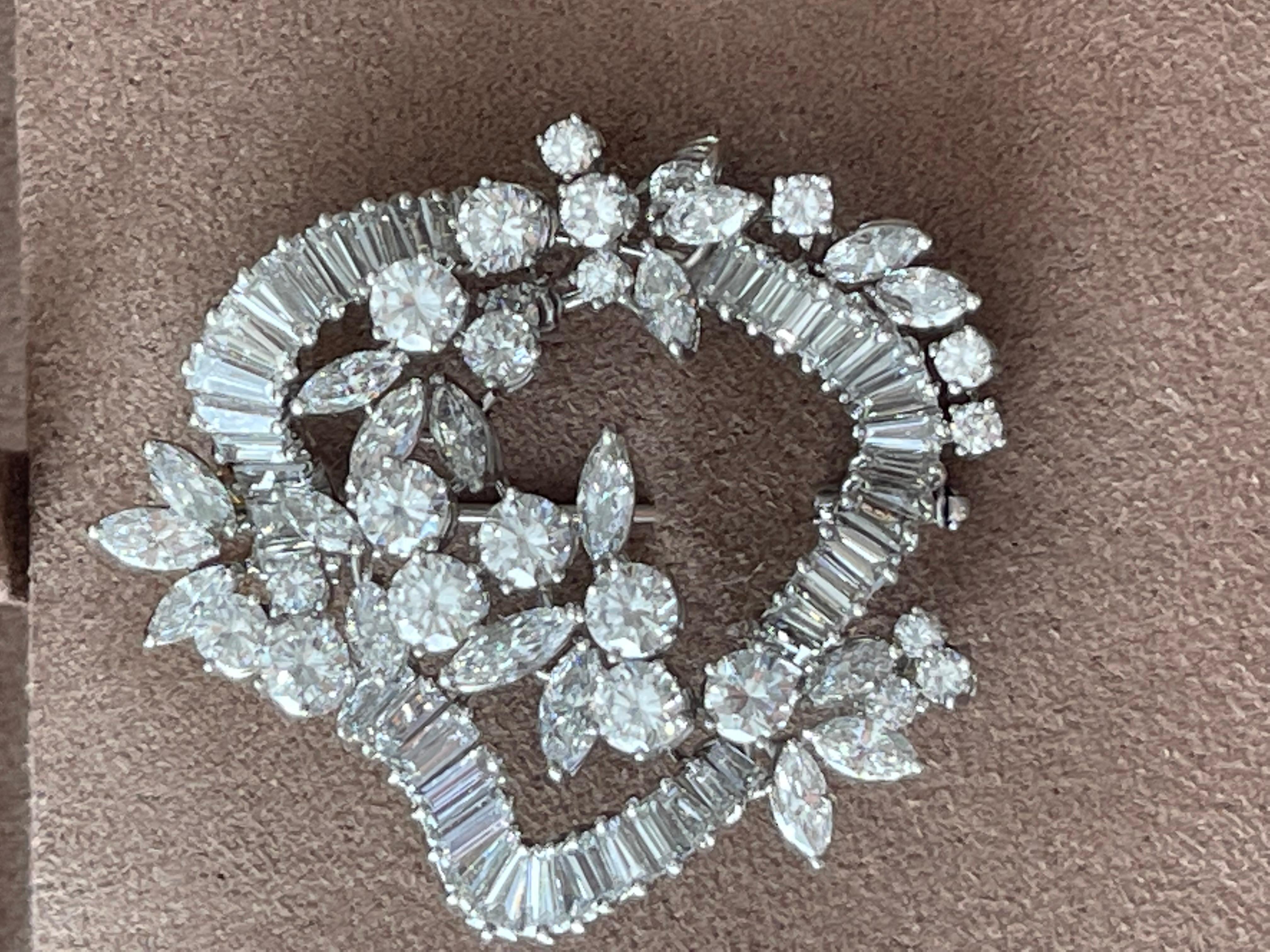 18 K white Gold  brooch featuring brilliant cut Diamonds, Baguette-cut Diamonds and Marquise cut Diamonds in an organic cluster design typical for the 1970. 
No pictures can do justice to this shiny and attractive item, but once it’s on, it is hard