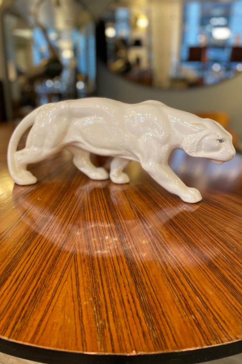 Una pantera in ceramica bianca degli anni '70 con un occhio argentato. 
La pantera mostra i segni dell'usura data dal tempo, ma conferisce il giusto sapore degli anni passati.

Misure: 46 cm x 12 cm x H. 18,5 cm

Il prezzo include i costi per