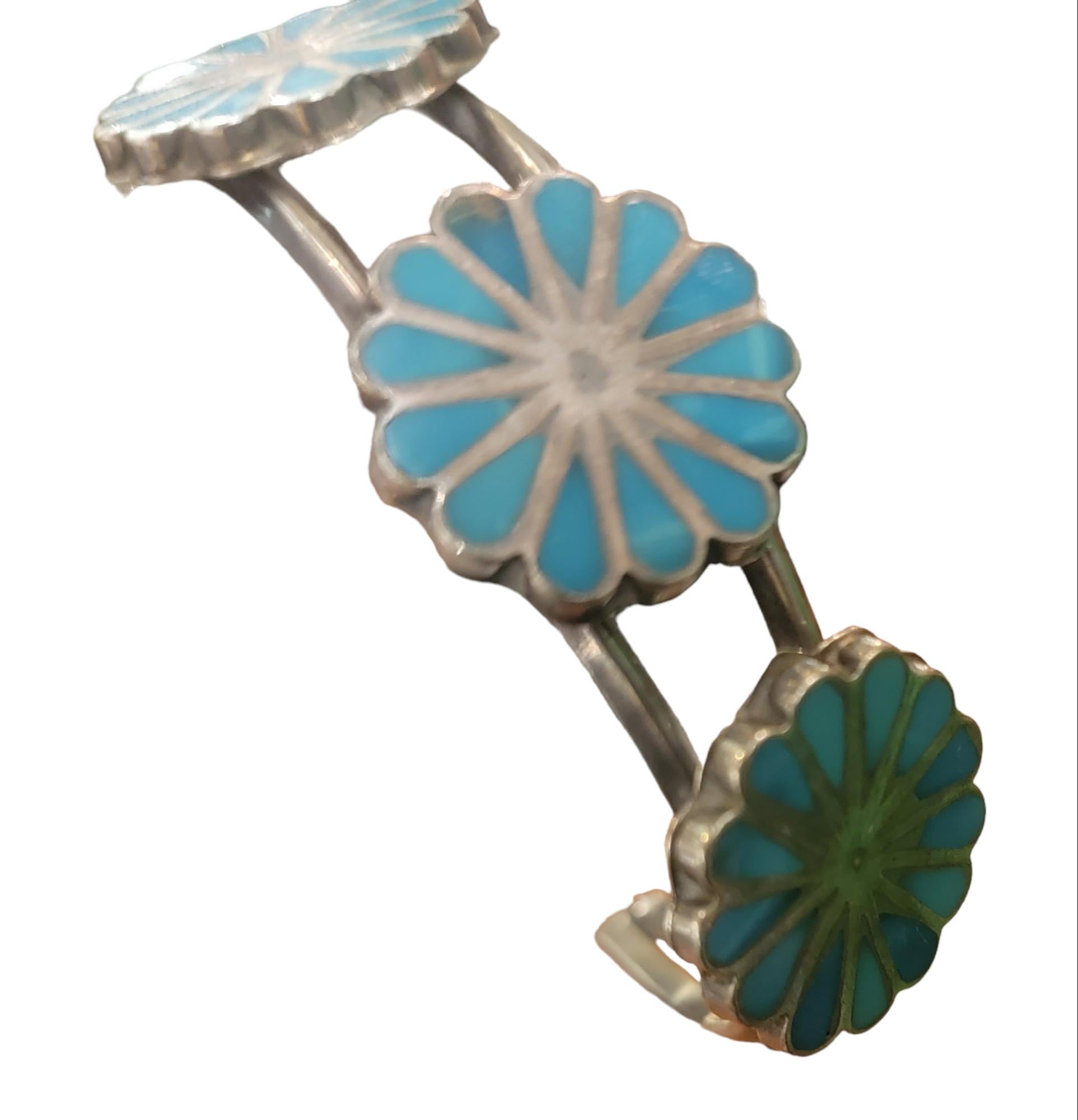 1970 Zuni Inlay Navajo Sterling Turquoise Cuff Bracelet. 
This wonderful cuff sterling bracelet has turquois inlay. The sun design is believed to provide warmth, growth life and all the is goo in this world. 
Corals are believed to be a Zen item and