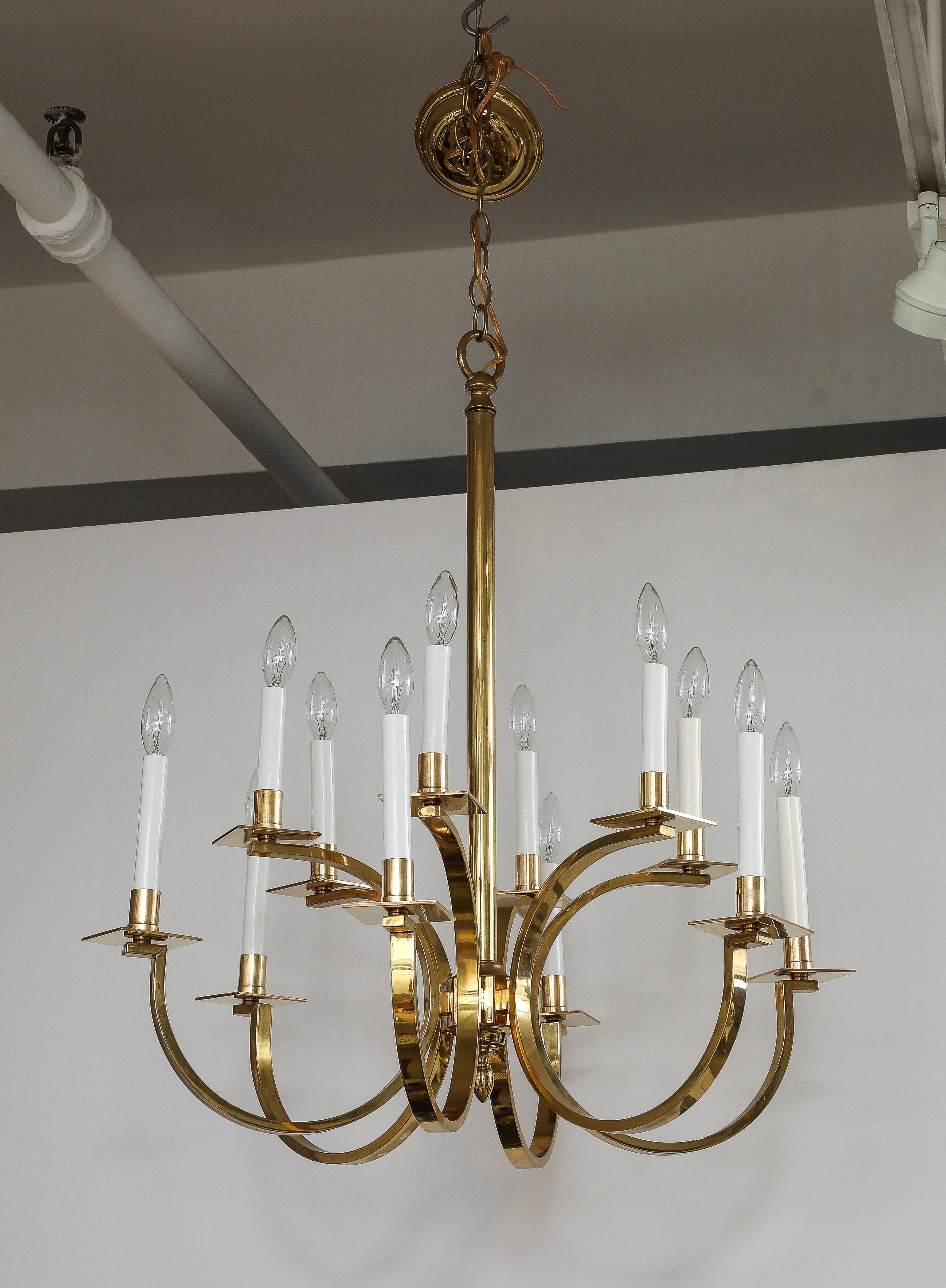 Lampadario in ottone a 12 bracci della metà del secolo scorso, attribuito a Gaetano Sciolari, appena ricablato e pronto all'uso, con alcuni segni di usura e patina sull'ottone dovuti all'età e all'uso.