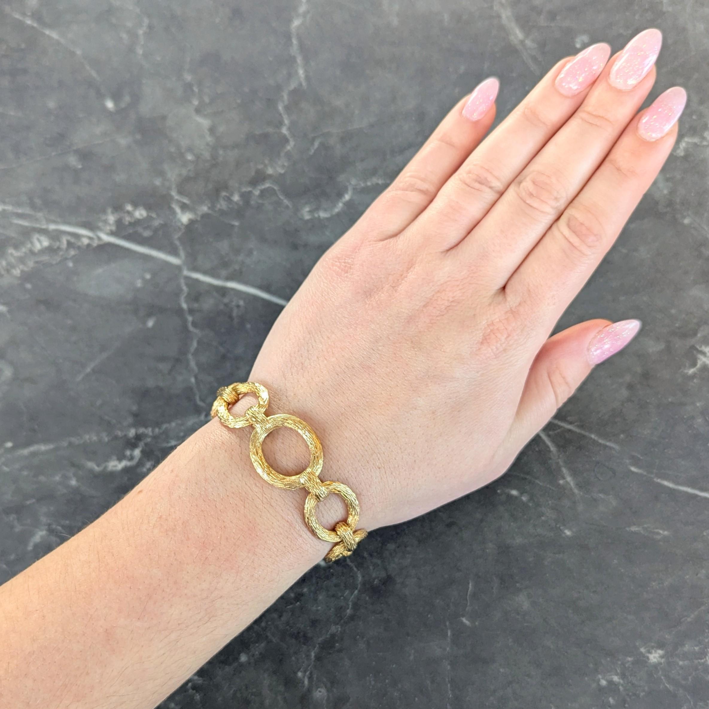 Designed as a stylized fancy link chain with oval and bar links
Featuring a grooved organic wood grain texture throughout
With high polish finish
Completed by concealed hinged clasp closure
With figure eight safety
Stamped with British hallmarks for
