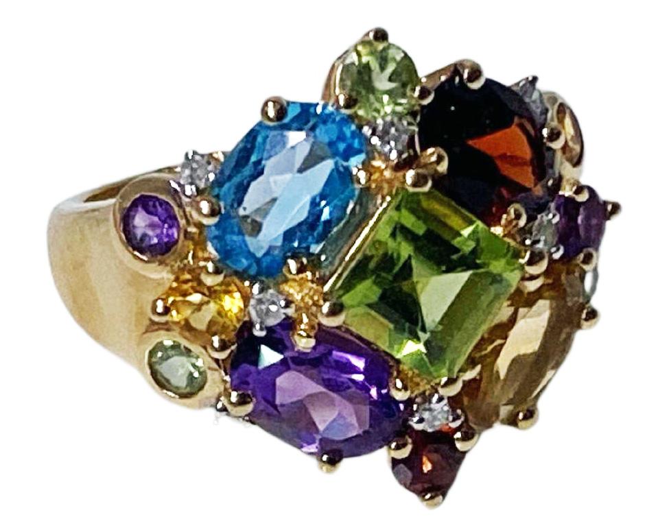 1970’s multi coloured Gemstone and 14K Gold Ring. The ring set with singlecut diamonds, peridot, garnet, citrine, amethyst and blue topaz. Ring top measures 20 x 18 mm.  Size 7. Item weight 6.48 grams. Stamped 14K inside shank. Ring may be sized.
