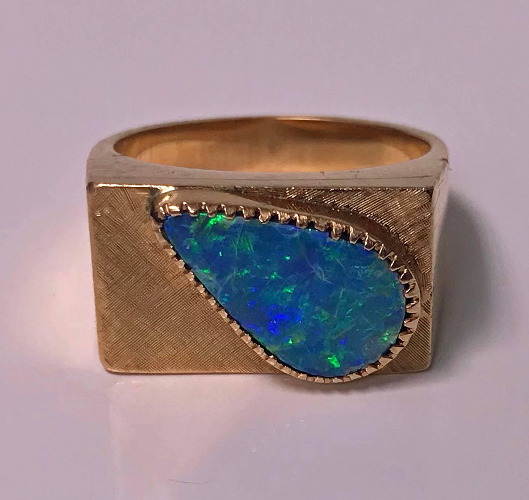 1970’s 18K Pink Gold Opal triplet Ring. The Ring set with a pear shape opal triplet, gauging 15 x 9 mm, closed back setting, bright blue and green colours. The solid 18K pink or rose gold mount with textured finish top and plain polished gold