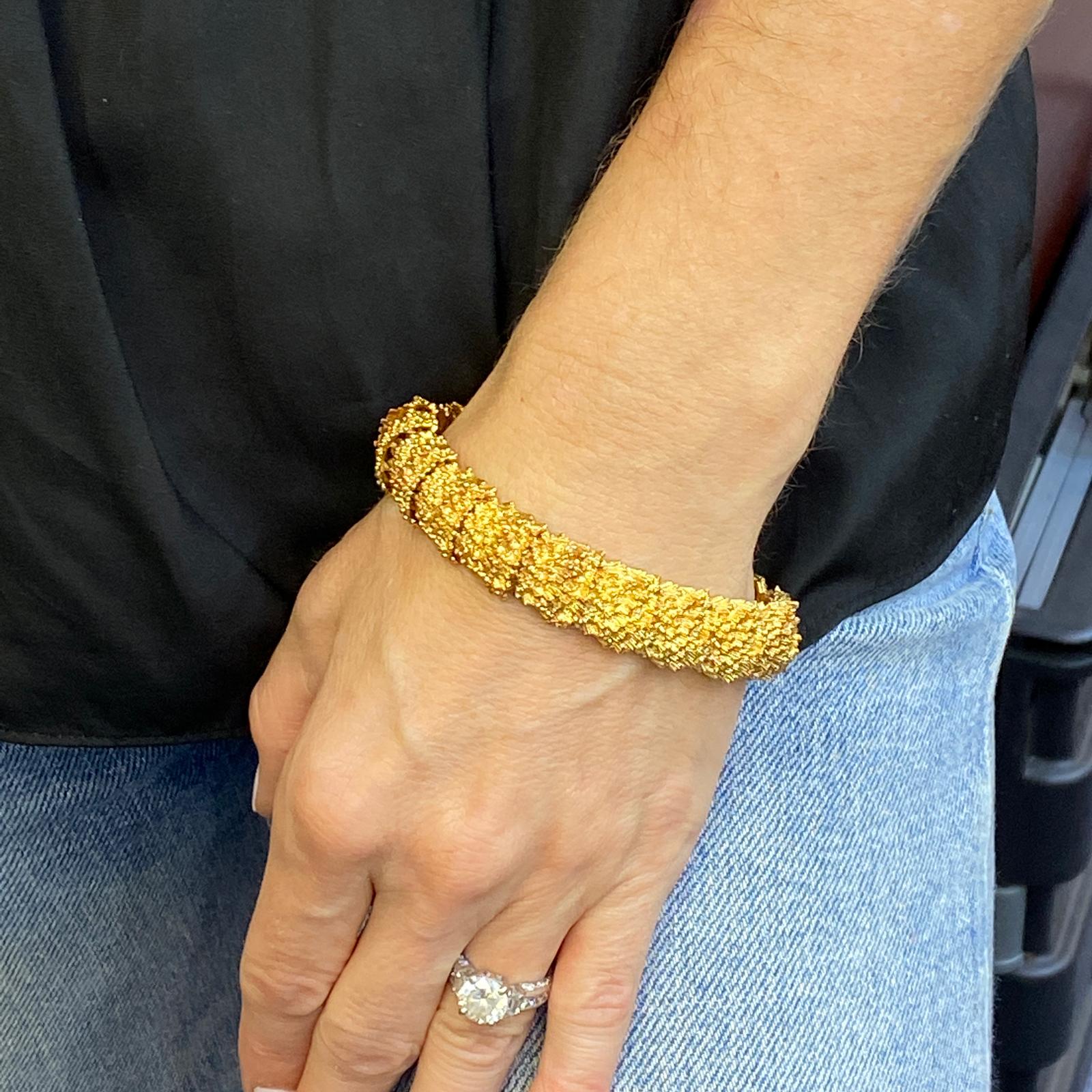 1970's textured vintage link bracelet fashioned in 18 karat yellow gold. The bracelet is flexible but sturdy, measures 8.0 inches in length, and .55 inches in width. Hidden clasp. 