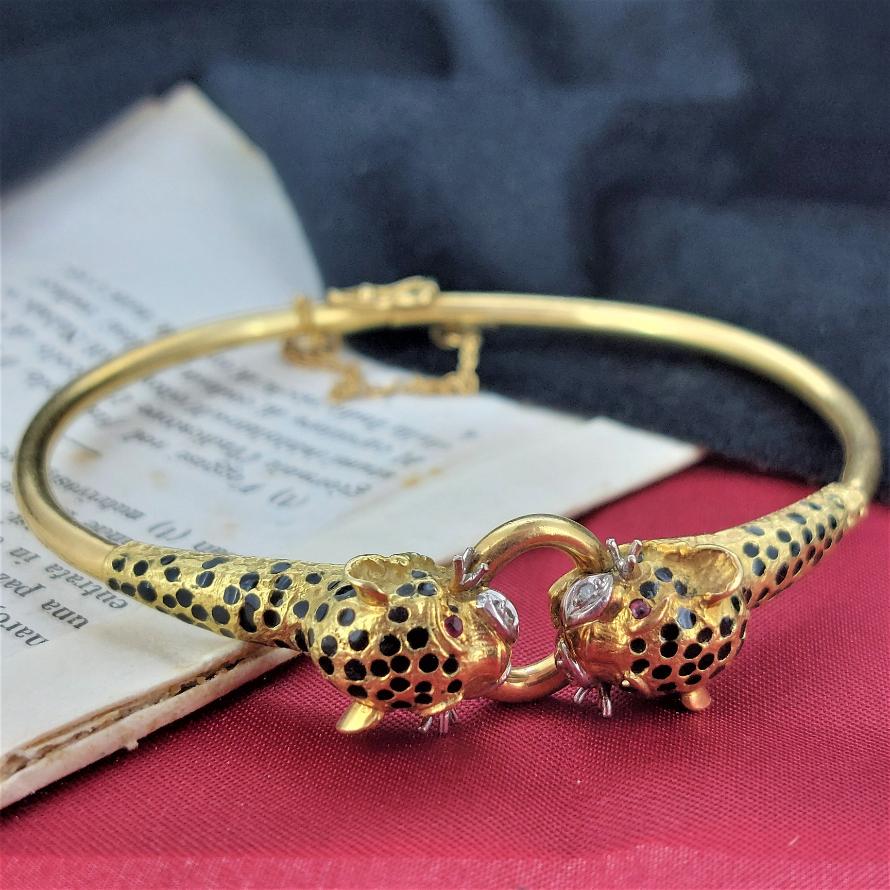 For the big cat lovers out there! 

Dating back to the 1970s here we present a double jaguar head bangle adorned with ruby eyes, diamond snout and black enamel spots - ROAR! 

The contrast between the rich 18ct gold patina and the black enamel is