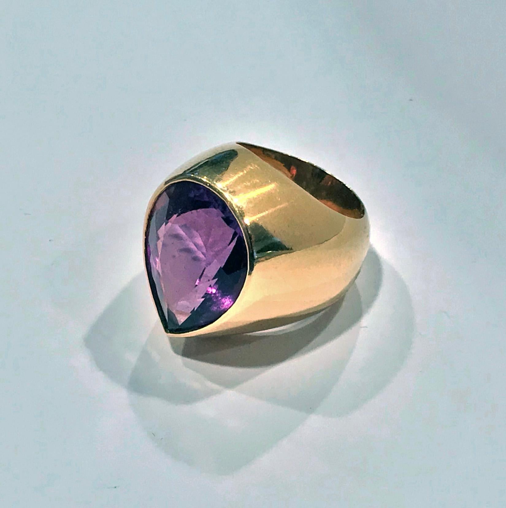 1970’s 18K Amethyst large Ring. The Ring set with a fine purple pear shaped amethyst gauging approximately 21.00 x 16.00 x 10.04 mm, approximately 17 cts, plain wide tapered custom mount and shank. Stamped Aarhus on interior of shank and maker’s