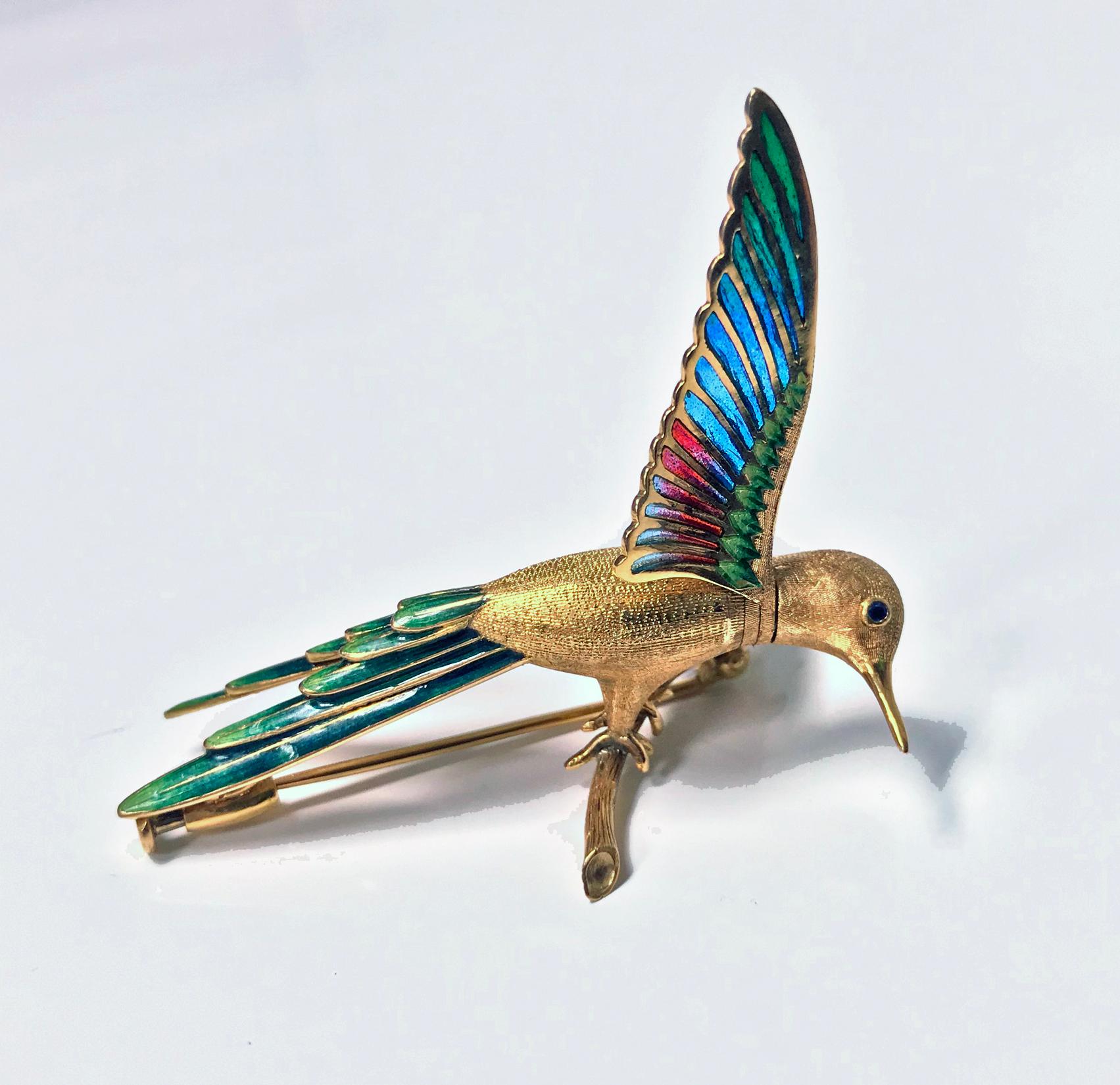 1970’s 18K Enamel Humming Bird Brooch.  The pivoting head and body with plique - a- jour and painted enamels in various colours of red, green and blue. The bird itself surmounted on twig branch, the eye set with small untested blue stone. Marked