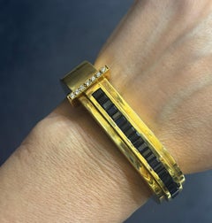 1970s 18k gold bangle with diamonds and approx 4 carats baguette cut sapphire