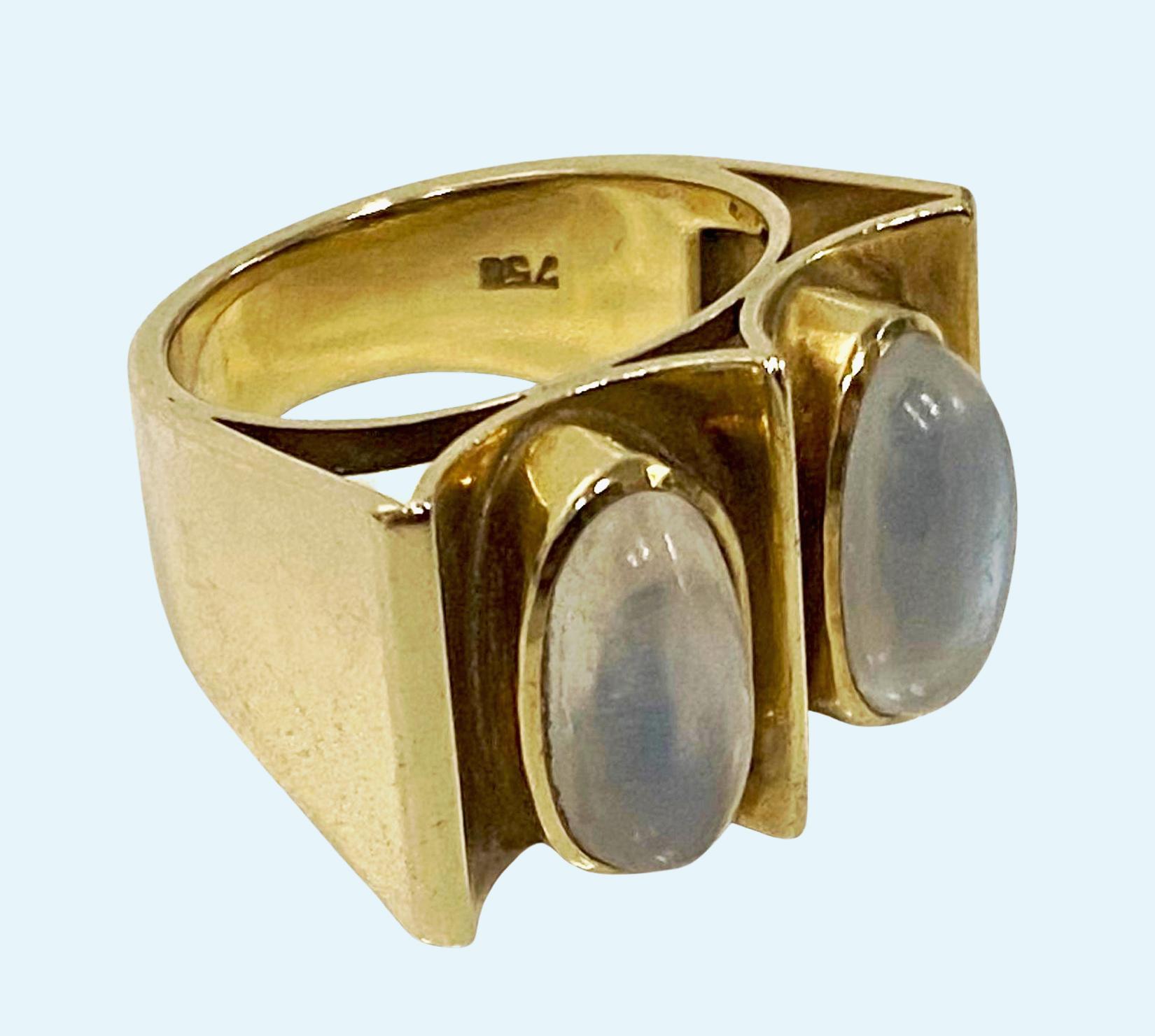 Bague moderniste abstraite en pierre de lune 18K des années 1970. Magnifique bague avec deux pierres de lune ovales en cabochon serties au chaton dans un cadre quadrilatéral à rainures, monture conique unie. Estampillé 750 à l'intérieur de la tige.