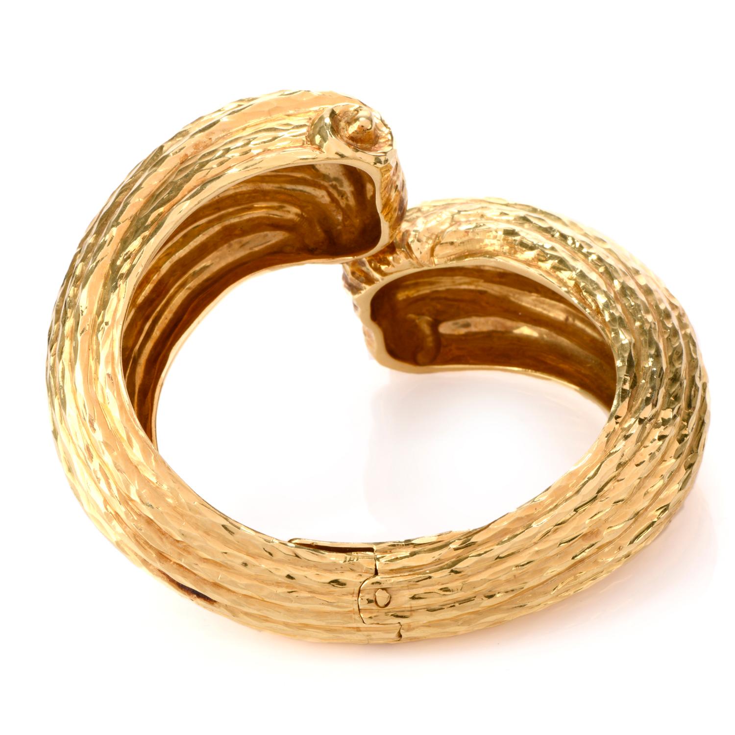 This incredible late 1970's 18K gold  cuff Bangle Bracelet was inspired in shell motif.

The ribbing of the shell design boasts a high polished hammered effect creating depth and interest.

The center of the vintage Bracelet is hinged for ease in