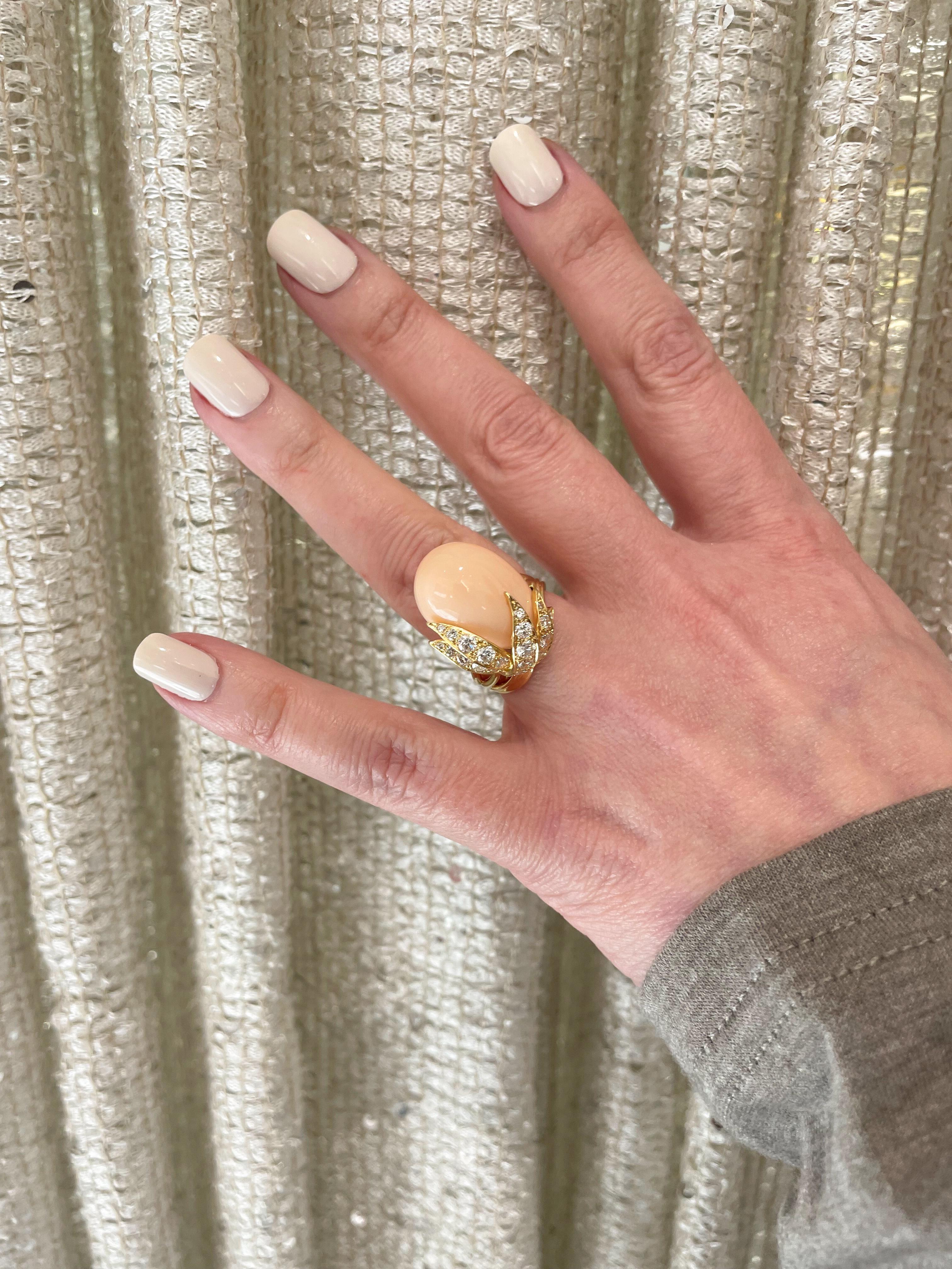 From the Eiseman Estate collection, circa 1970’s, 18 karat yellow gold angel skin coral ring. This ring is crafted with an egg shaped angel skin coral accented with yellow gold leaves. This ring also features 25 round brilliant cut diamonds with an