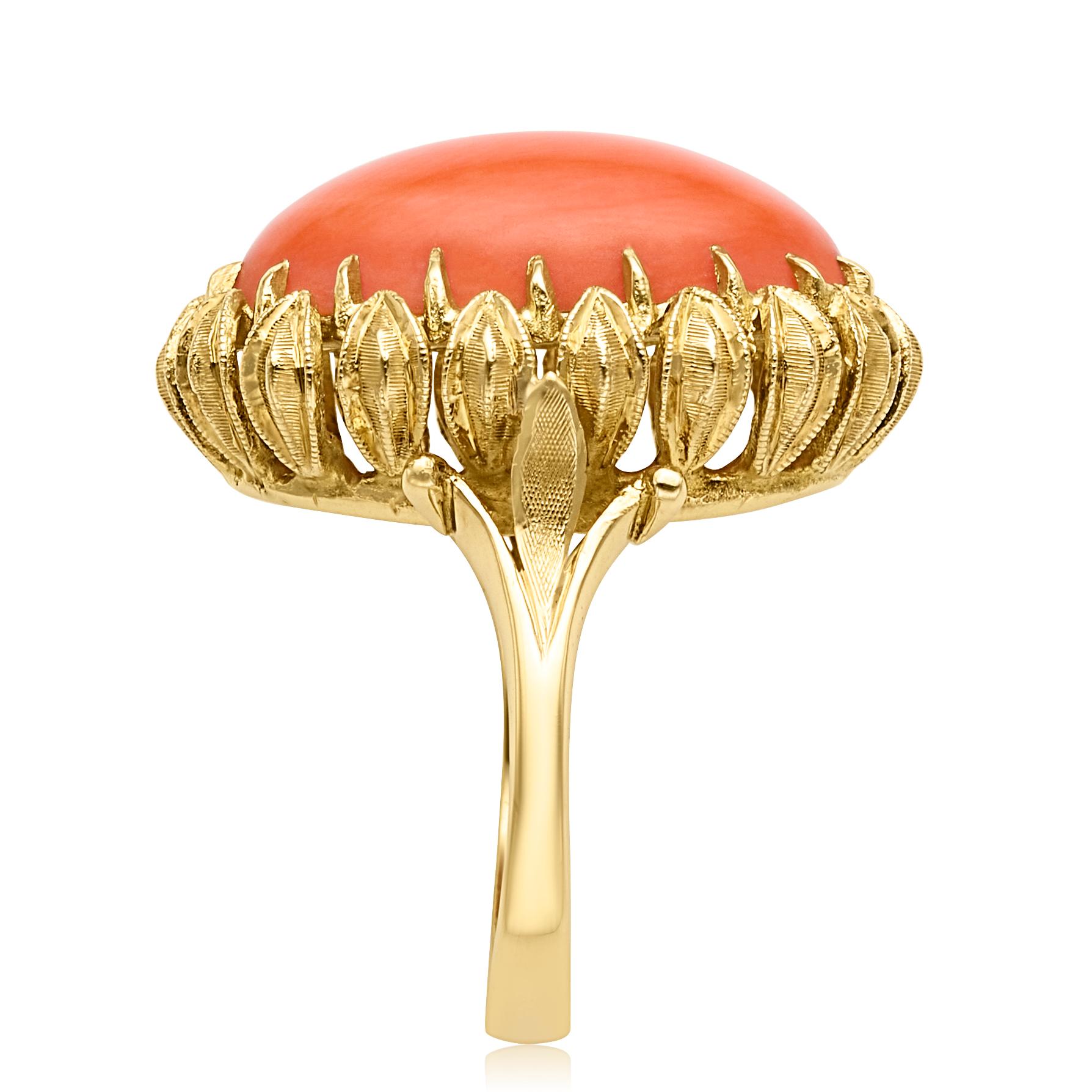 From the Eiseman Estate Jewelry Collection, circa 1970s, 18 karat yellow gold coral cocktail ring. This ring is crafted with a center oval cabochon cut coral stone measuring 20.12x12.21x5.97mm in diameter. The coral stone is in an ornate setting and