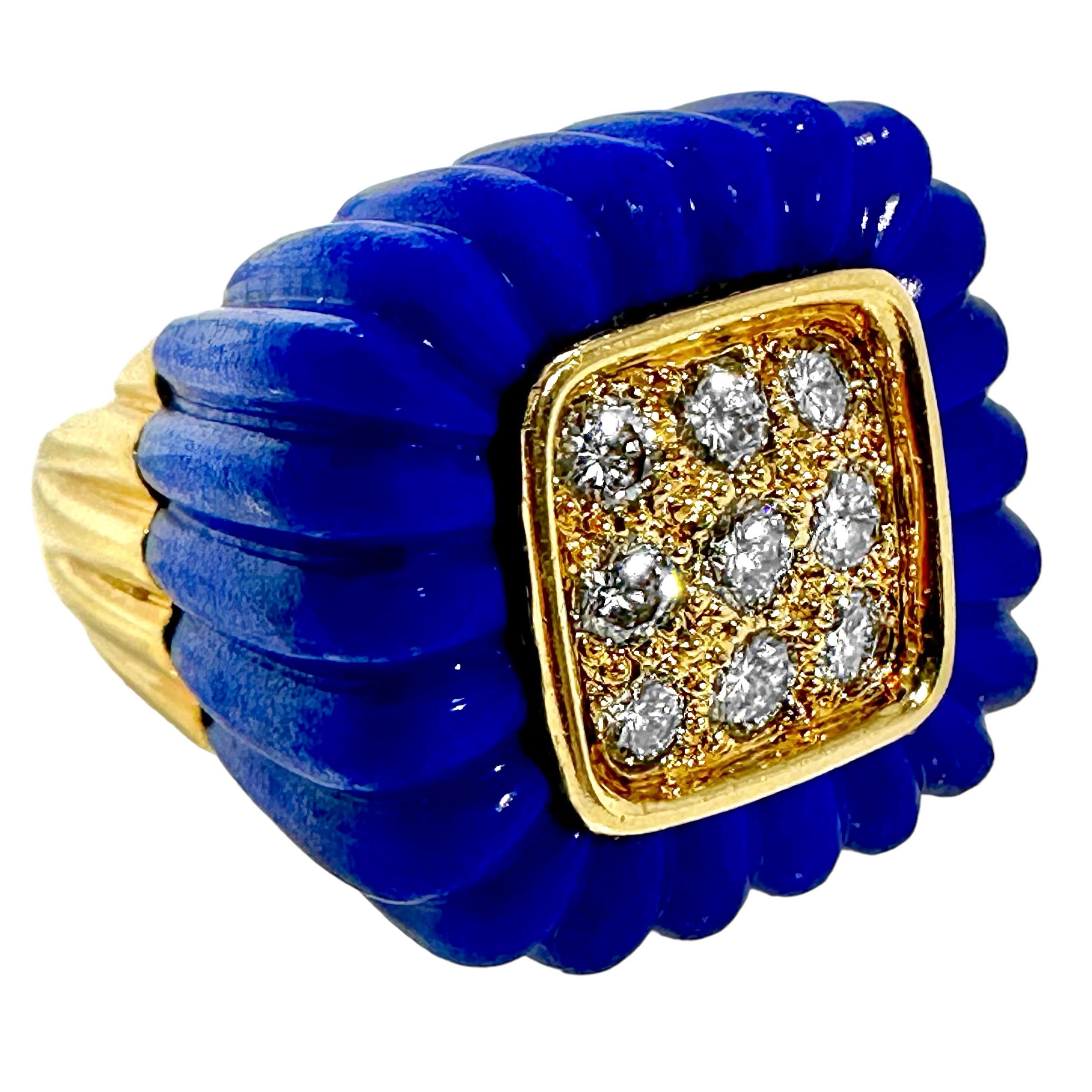 This large 1970's 18k yellow gold, diamond and fluted Lapius-Lazuli cocktail ring is comprised of a central cushion shaped recessed gold plate set with nine round brilliant cut diamonds, having a total approximate weight of 1.00ct. Overall diamond