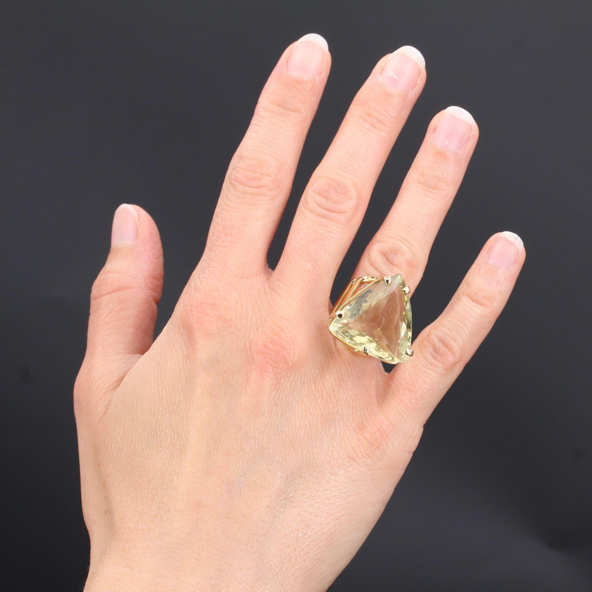 Ring in 18 karat yellow gold.
Surprising retro ring, it is decorated on its top with a lemon quartz of triangular form set with 5 claws. The setting, heightened and openwork, is made of flat threads.
Weight of the quartz : 23 carats