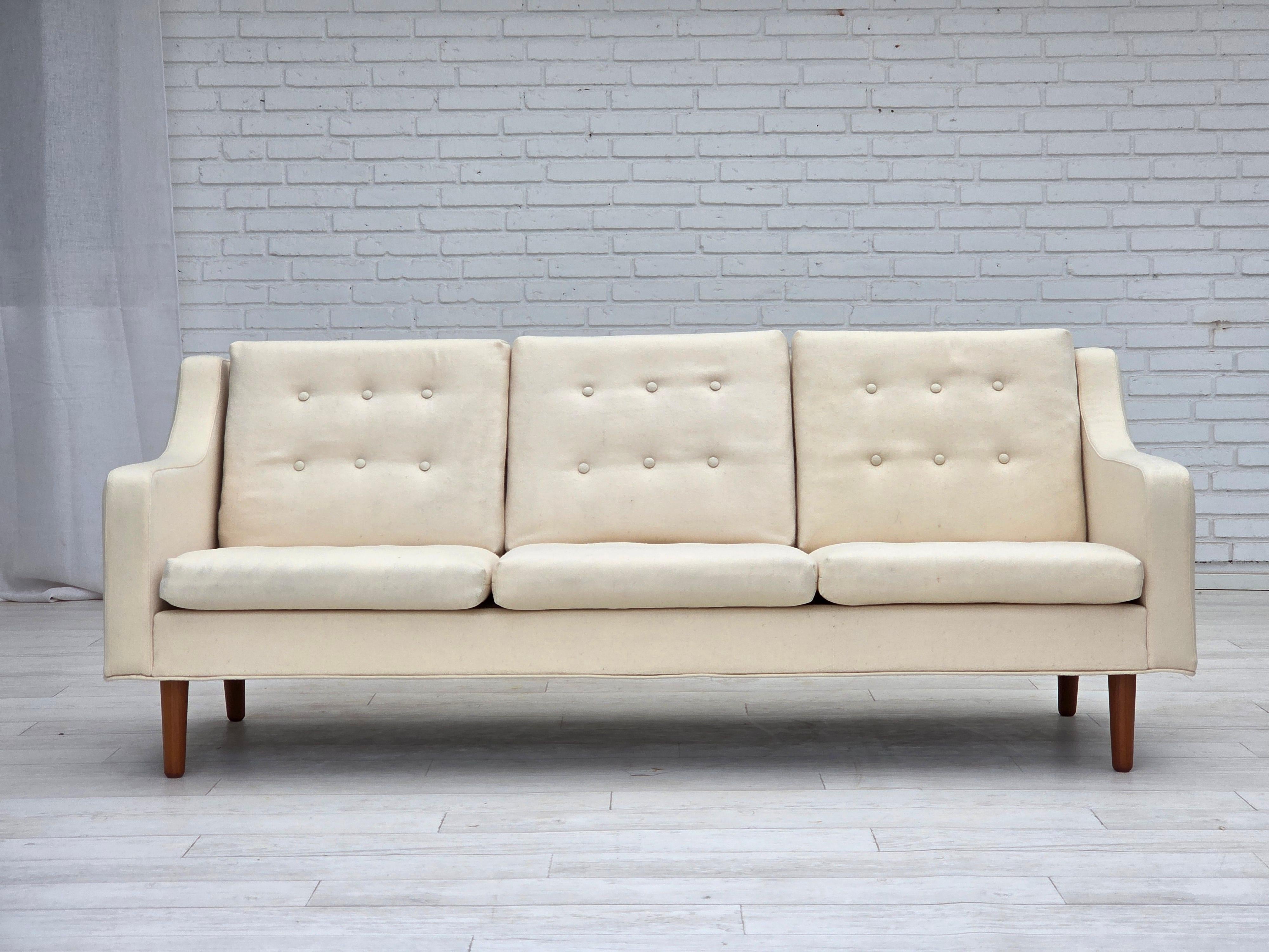 1970, canapé danois à 3 places. Laine d'ameublement beige/blanc, pieds en teck. Le canapé a été retapissé par un artisan il y a environ 15 ans. Fabriqué par un fabricant de meubles danois dans les années 1970-1975. Bon état : pas d'odeurs, pas de