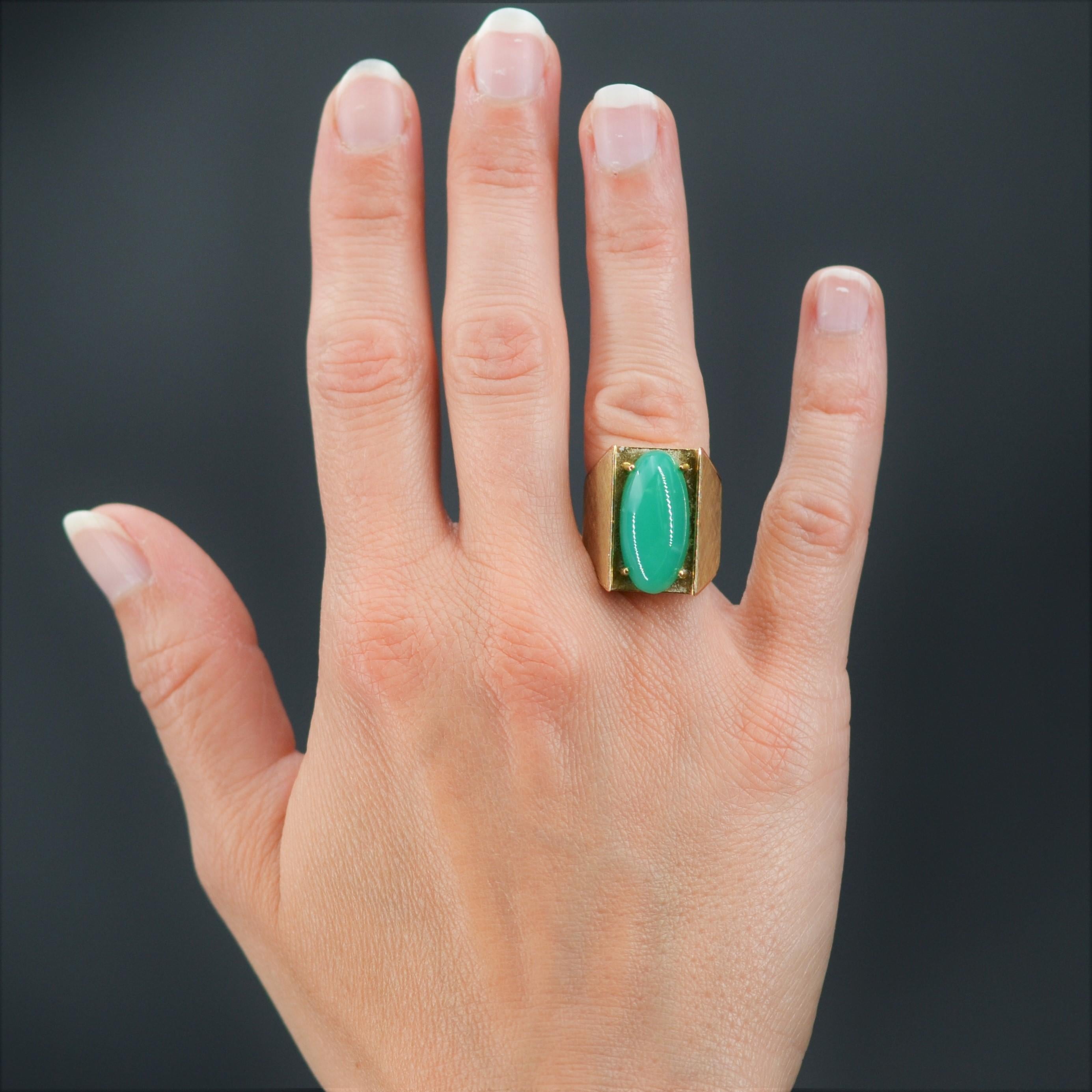 Ring in 18 karat yellow gold, owl hallmark.
Important retro signet ring, it presents a geometrical tray decorated with an important oval cabochon of chrysoprase, retained with 4 claws. On both sides, the wide setting is flat and brushed.
Weight of