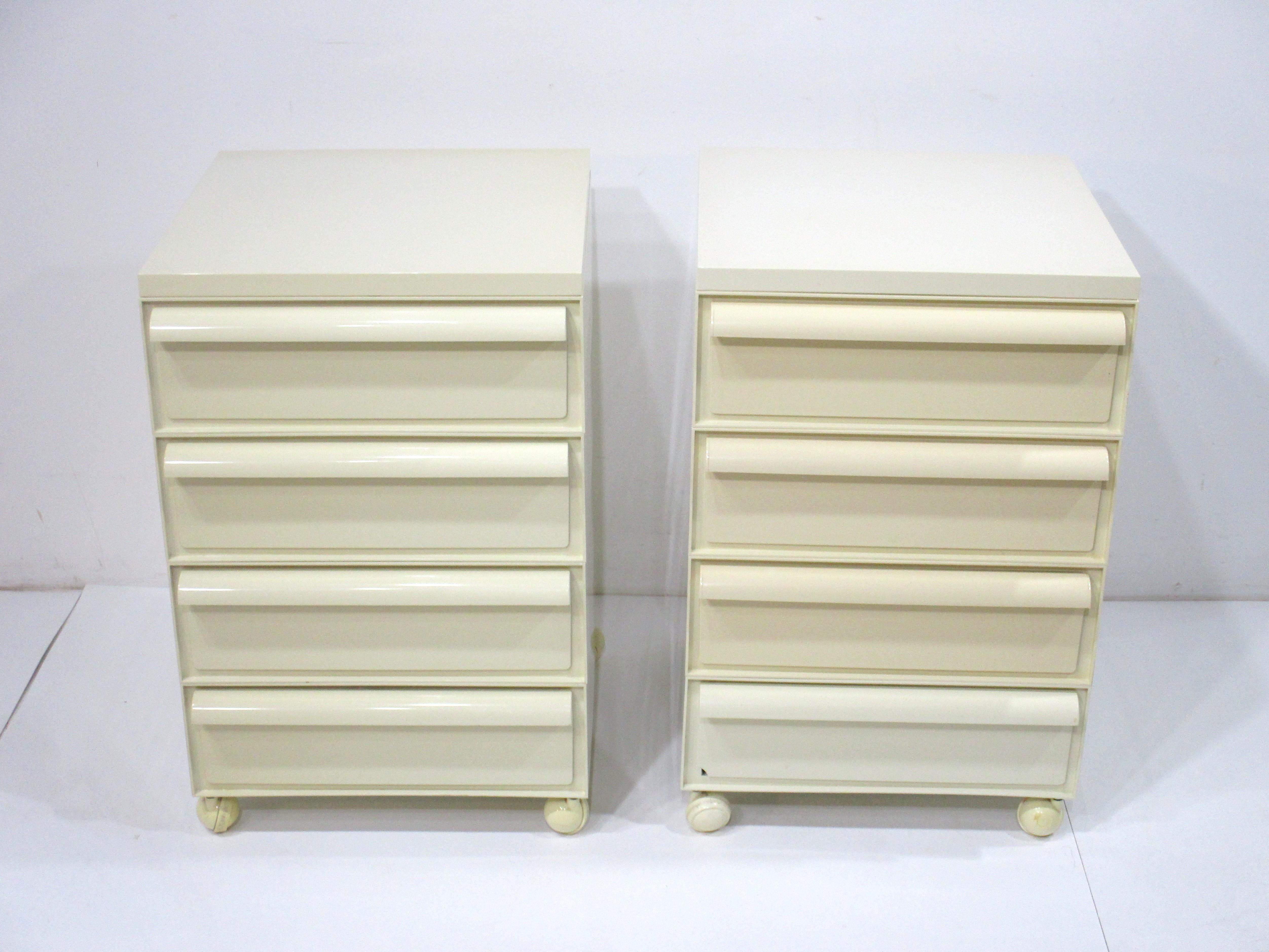 A pair of ABS plastic formed nightstands each having four drawers and sitting on matching wheels . These space age pop modern looking pieces are manufactured by Kartell and made in Italy , designed by Simmon - Fussell - Castelli , includes custom