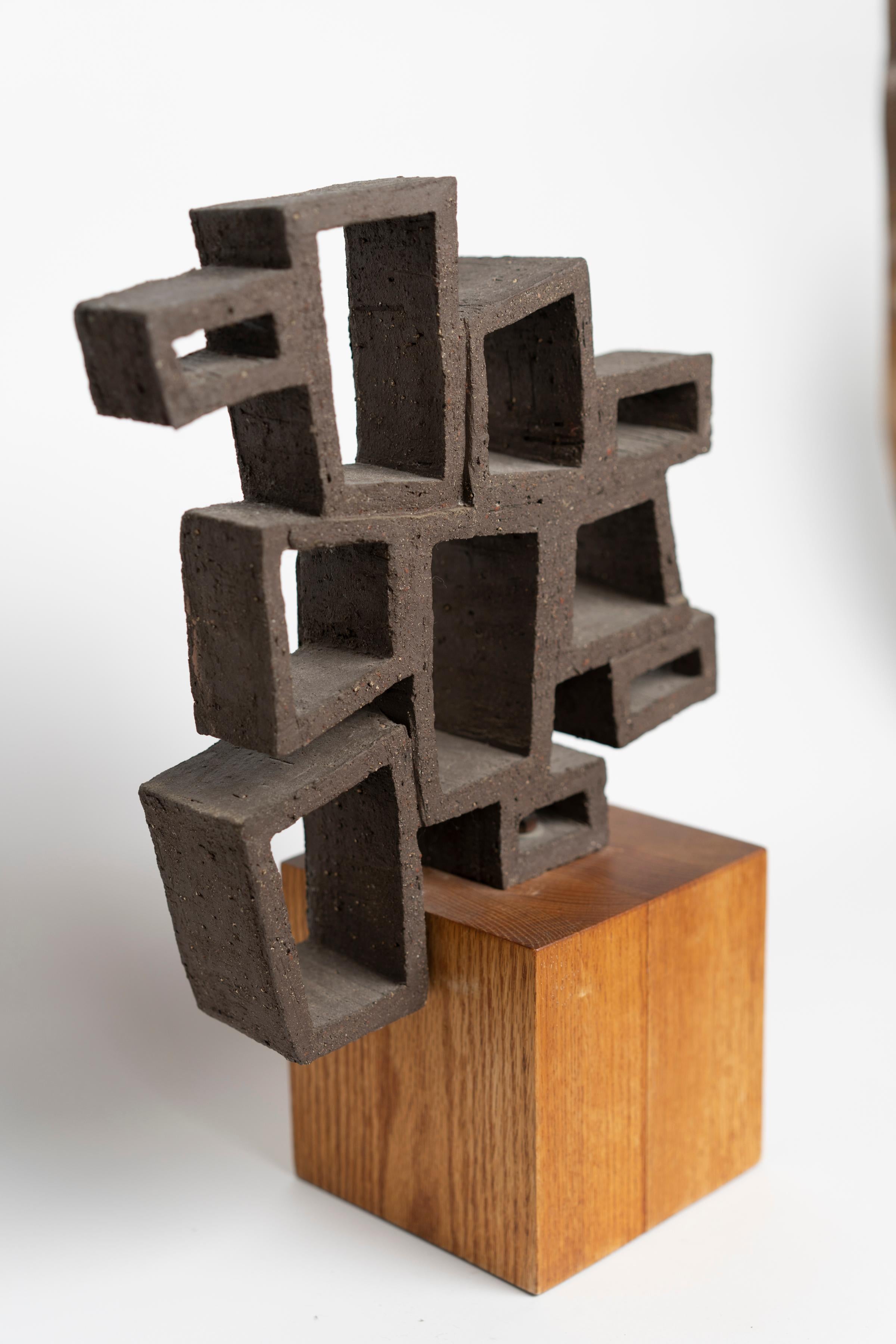 Sculpture réticulée abstraite en céramique des années 1970 reposant sur une base en bois.
