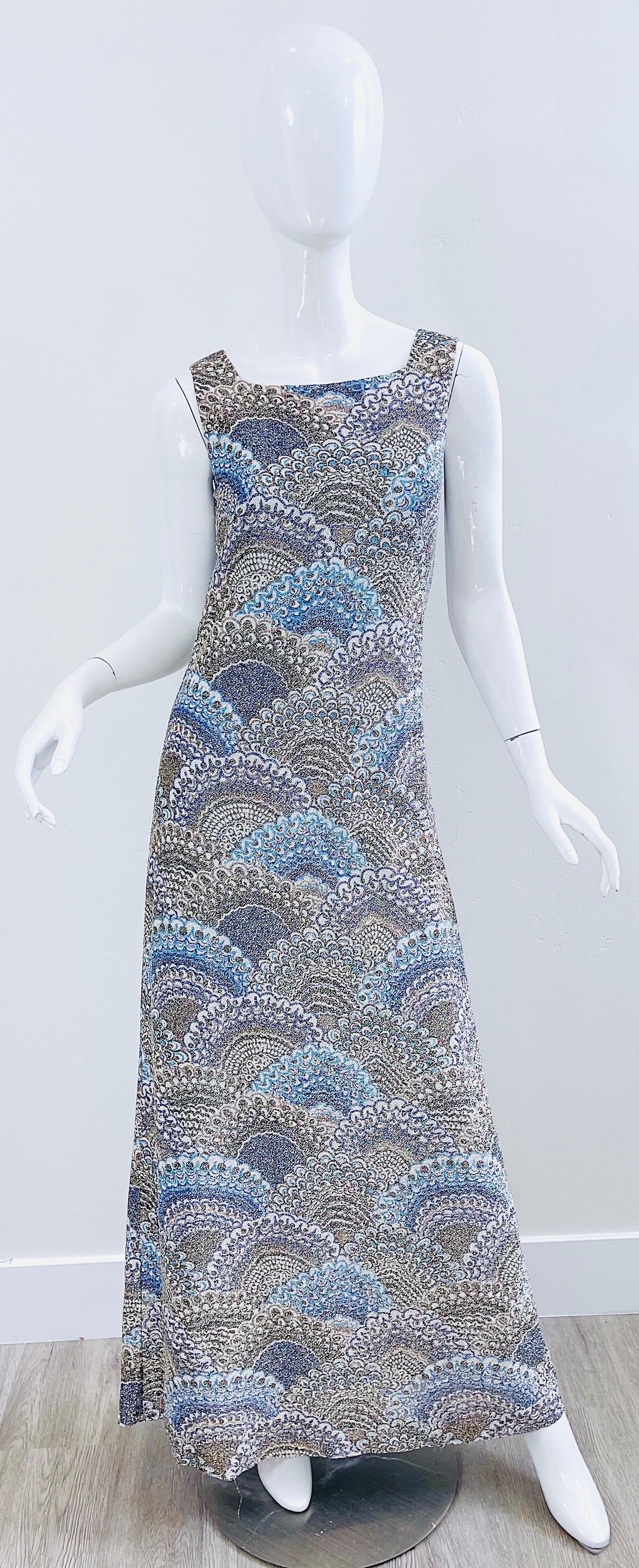 Magnifique robe longue sans manches en lurex de soie bleu et argent métallisé d'ADELE SIMPSON datant du début des années 70 ! Il est orné de plumes de paon et de motifs d'éventail. Fermeture à glissière en métal cachée dans le dos avec fermeture à