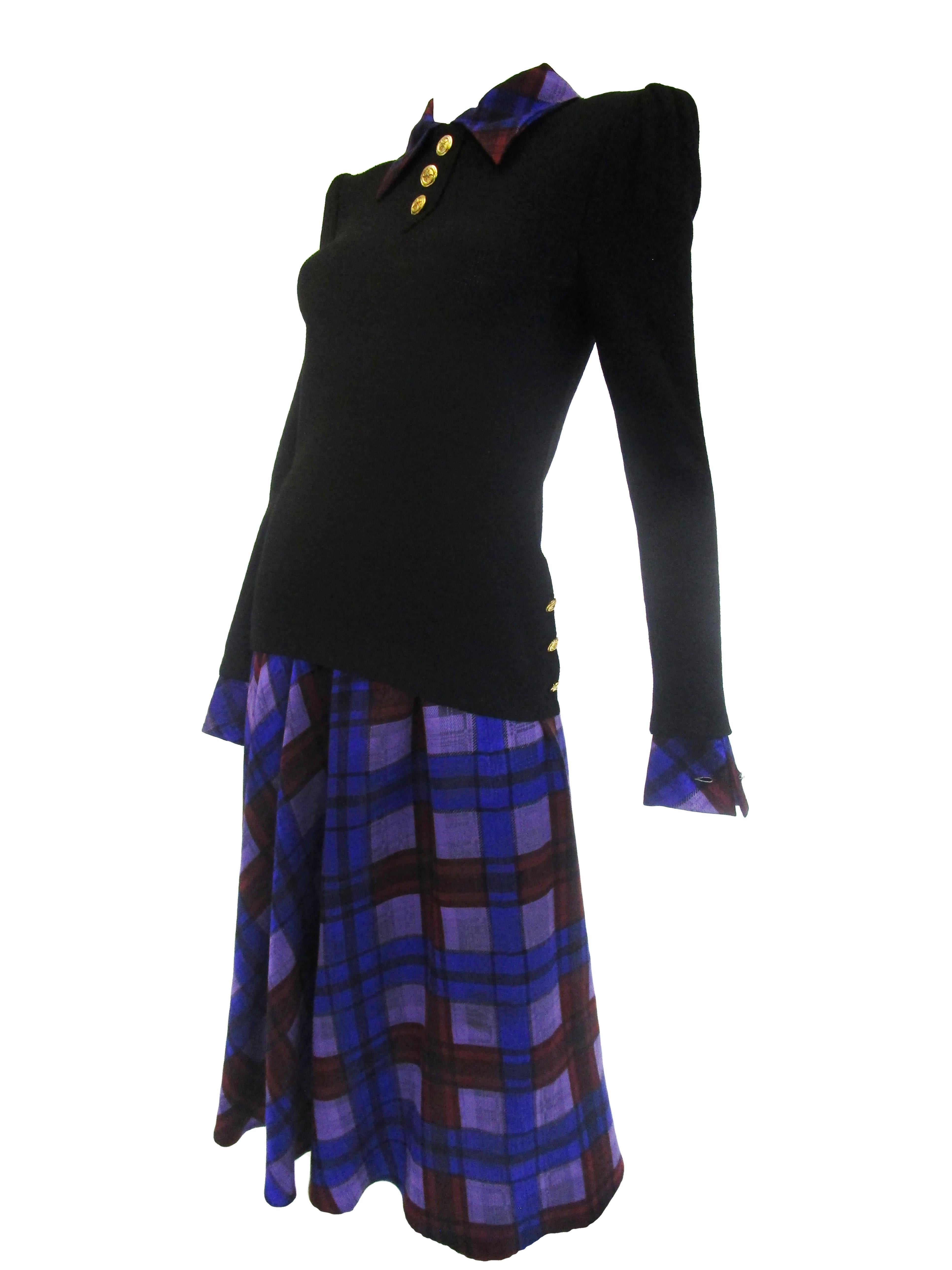 
This Adolfo sweater and skirt set is the perfect balance between fitted and flowing hitting all the pulse points of your figure.
It features a cozy black long sleeve sweater top adorned with gold buttons and a beautiful purple and red plaid silk