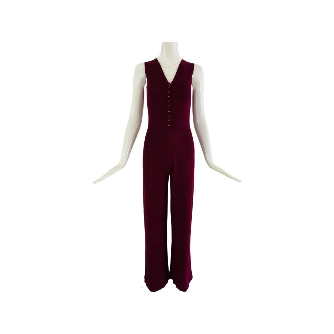 1970s Adolfo Saks Fifth Avenue jumpsuit in a burgundy knit, sleeveless with wide legs.  Fitted at the top and 10 ball acrylic buttons closure from a V-neck down to the navel. Appears unworn and in excellent condition.  No size or composition label