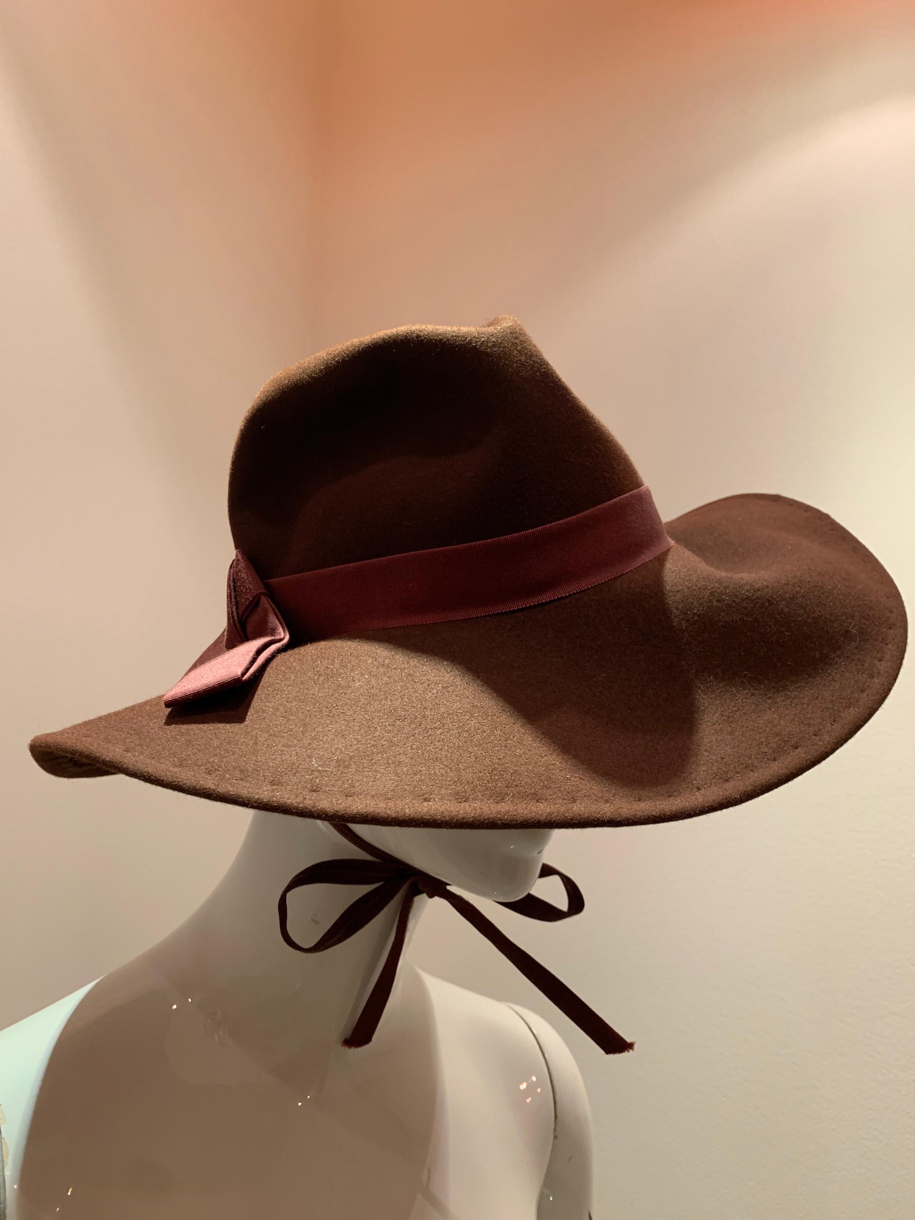 A handsome 1970s Adolfo wide brimmed menswear-styled chocolate brown wool felt fedora.  Ready for adventure with a chin strap to secure.  Trimmed with grosgrain ribbon band. 