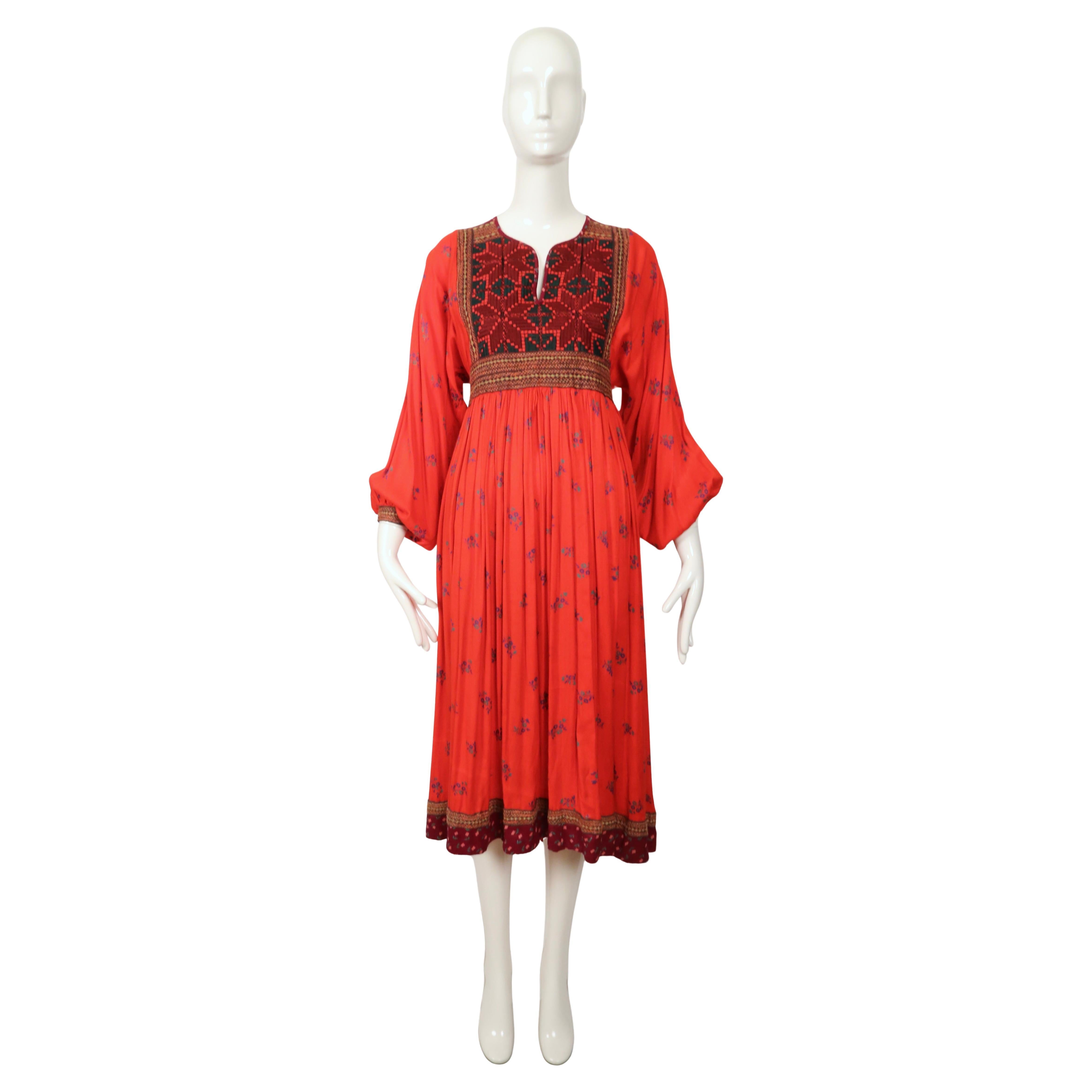 Hand-embroidered, floral printed folk style dress from Afghanistan dating the 1970's. No size is indicated although this dress best fits a size S. Dress was not clipped on size 2 mannequin. Approximate measurements: waist (elastic at back) 26