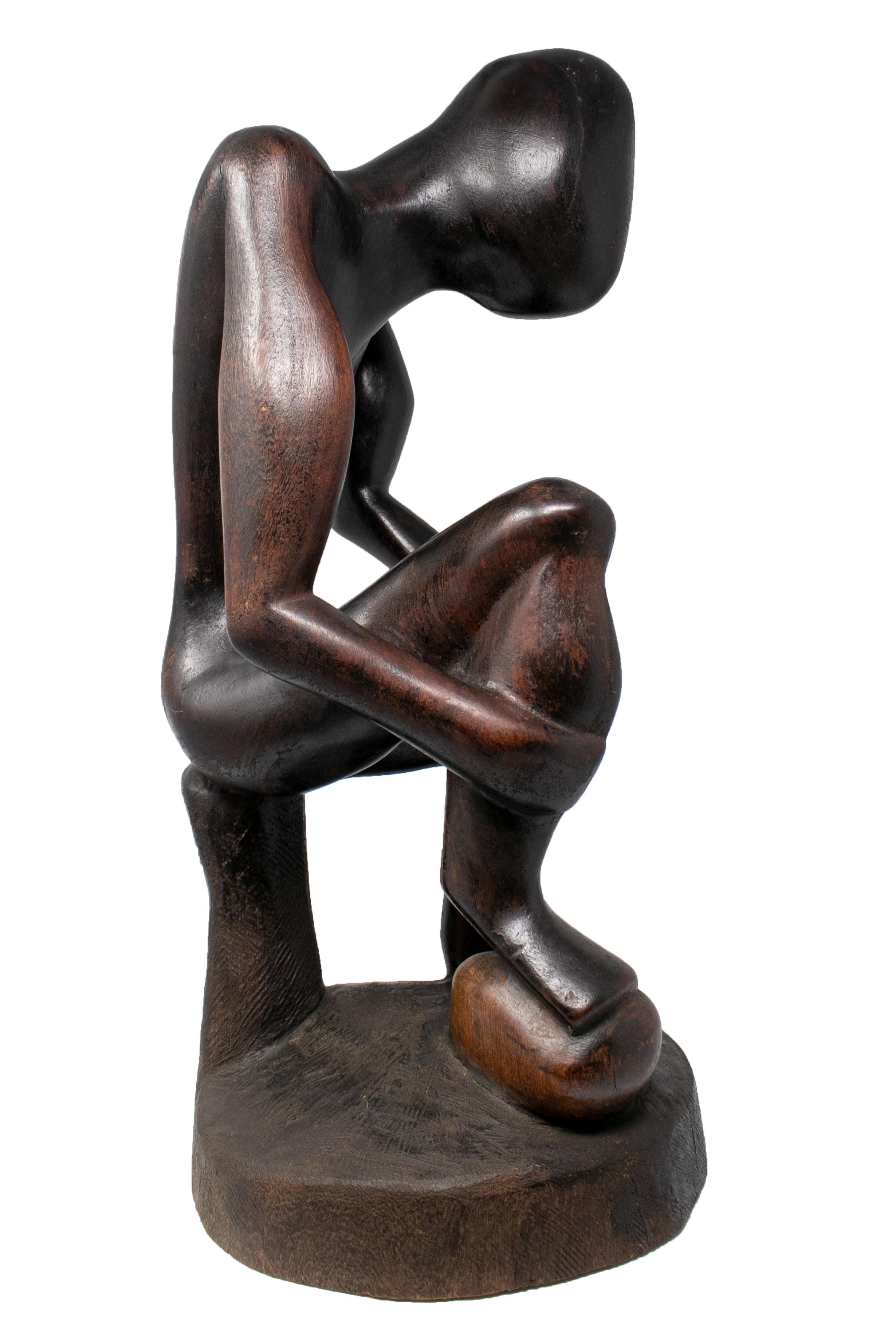1970s African hand carved wooden sculpture of sitting man.