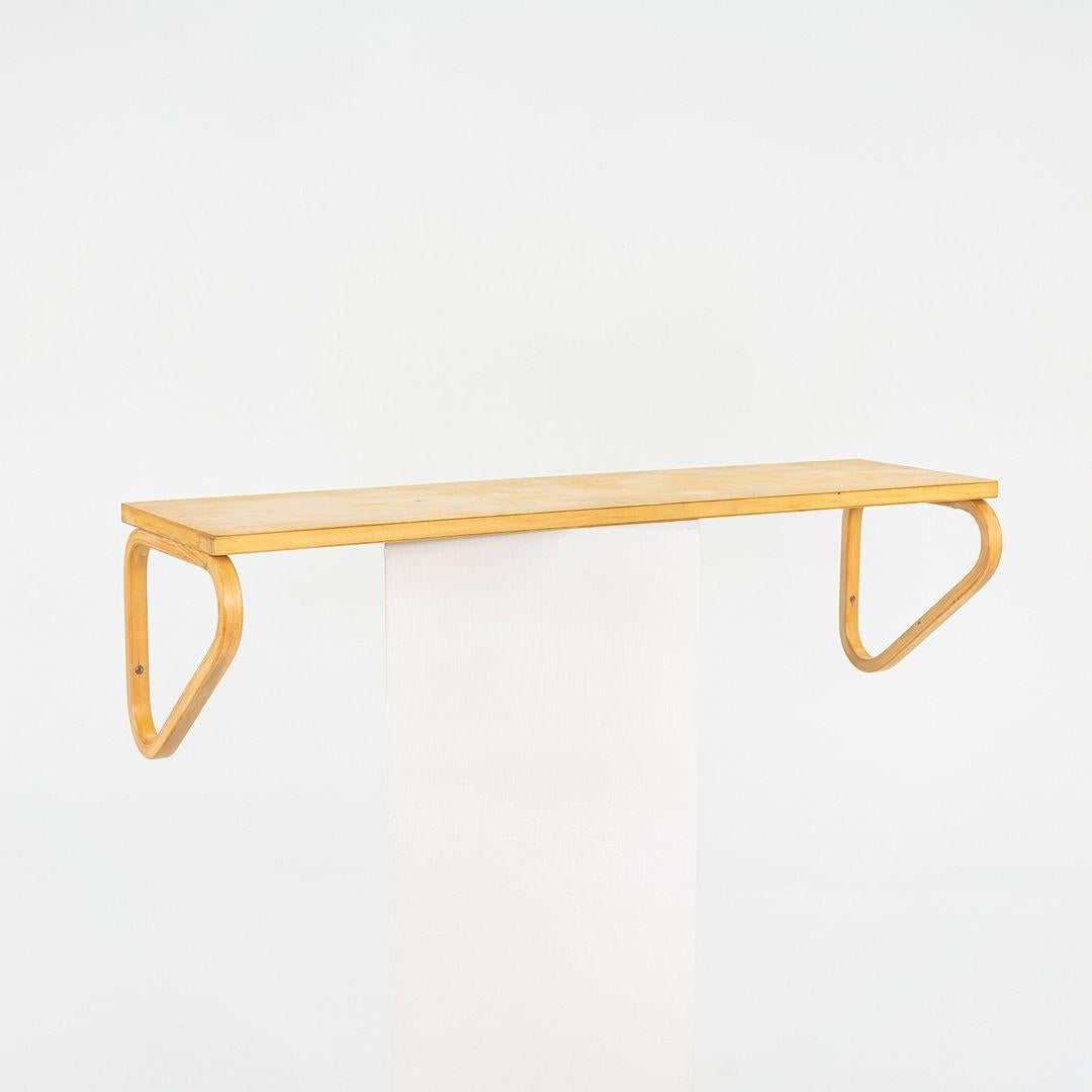 Si tratta di una mensola da parete, modello 112B, disegnata nel 1936 da Aino e Alvar Aalto per Artek. Questo pezzo risale agli anni '70. Il ripiano è formato da staffe in betulla piegata, che possono essere posizionate sia sotto che sopra il