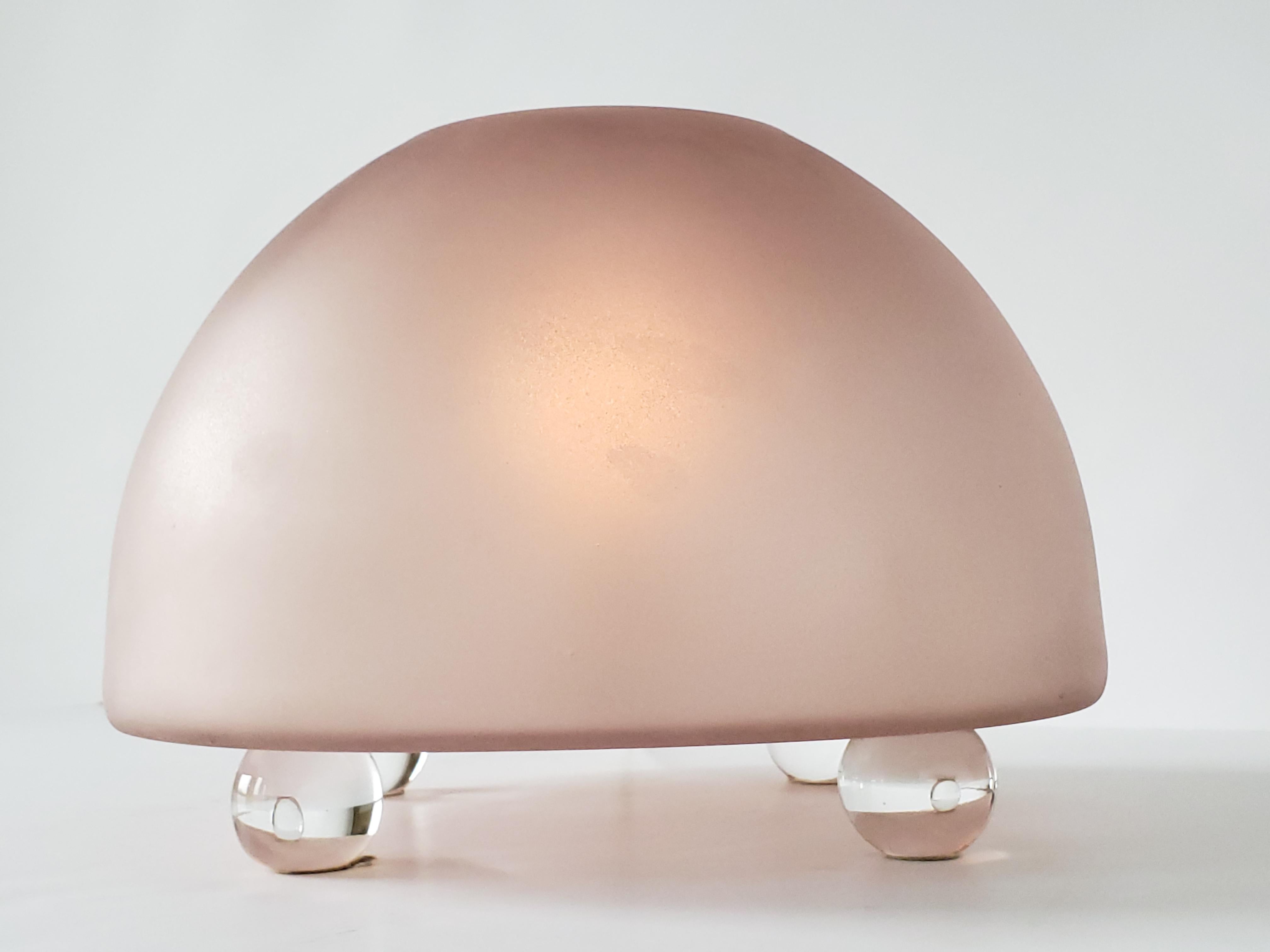 Minimalist modern etched thick glass lamp sitting on 4 mouth blowed glass ball. 

The glass is half of an inche thick.

In an old pink amberish tone 

Does provide a warm glow.

Contain one E27 size socket. 

Switch on cord.