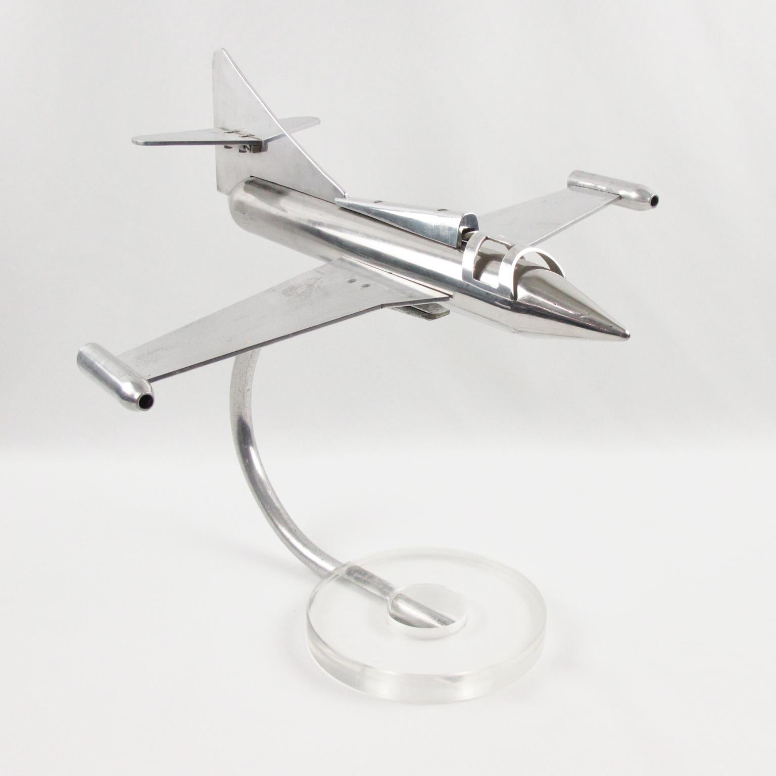 Stunning large polished aluminum airplane model, made in France, circa 1970s. Featuring an impressive jet plane model on thick clear Lucite slab base. Great desk accessory for aviation collector and lover. 
Measurements: 15.75 in. wingspan (40 cm)